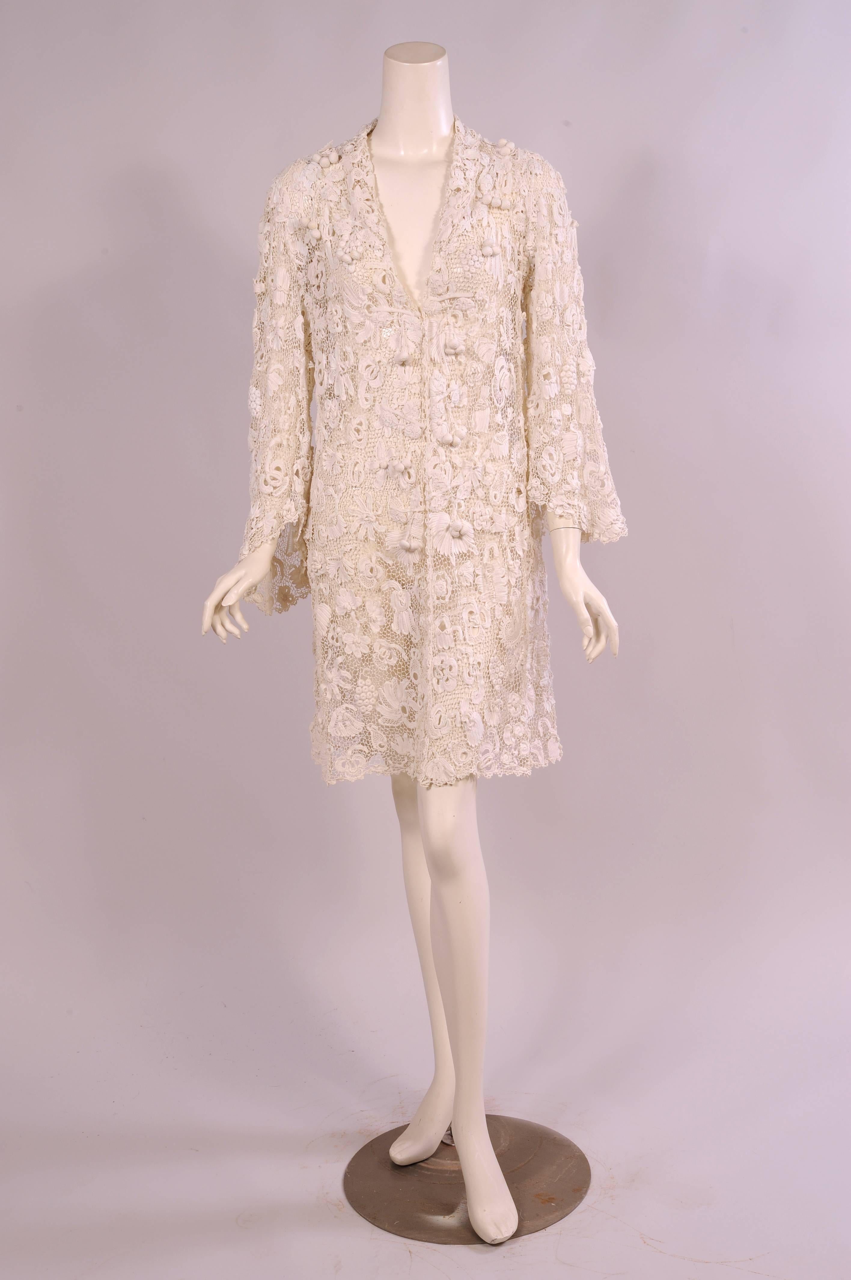 This stunning Irish lace coat has all of the wonderful design elements that you could wish for in a hand made lace coat. It even has three dimensional lace flowers and fabulous suspended ball ornamentation in groups of three all the way down the