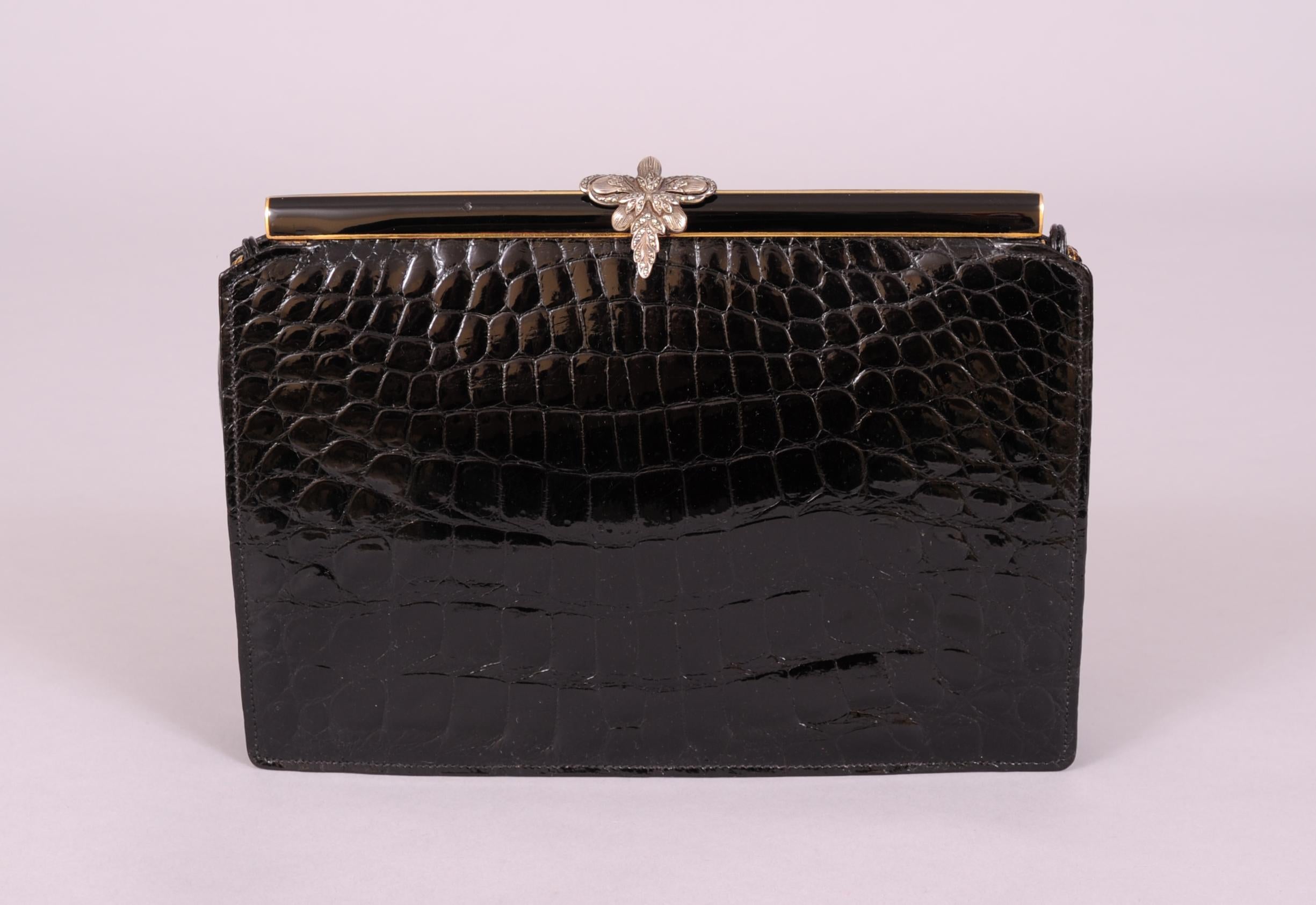 This stunning black crocodile evening bag is topped with a marcasite  set sterling silver clasp. The frame is black enamel over gold toned metal, front and back. The black crocodile skin is in pristine condition, as is the convertible handle. The