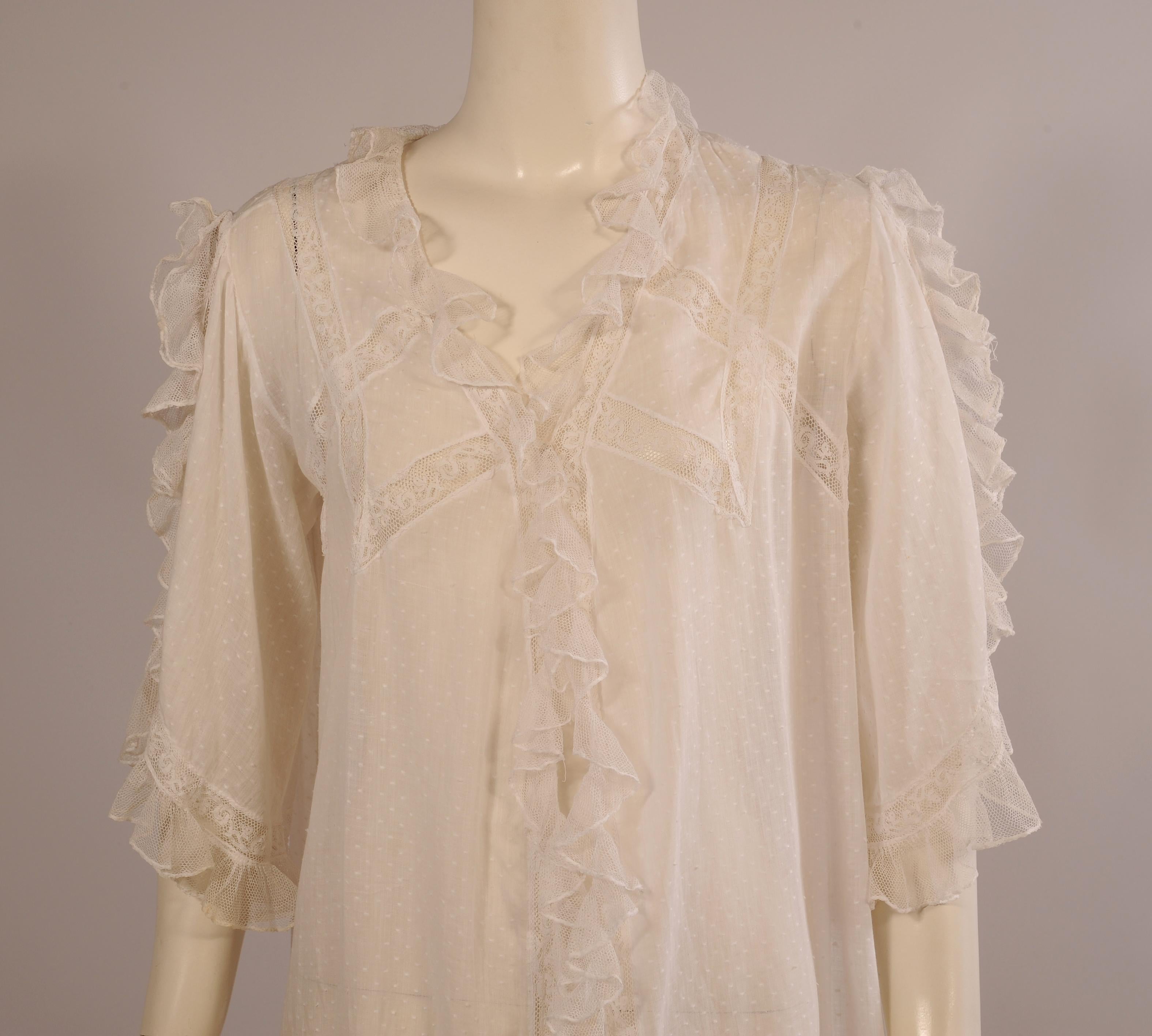 Slip into this feminine lace edged white dotted Swiss peignoir for a little vintage luxury. There is one hook and eye closure at the bust and the lace trimmed edges curve down toward the lacy hemline. The sleeves are full and repeat the lace