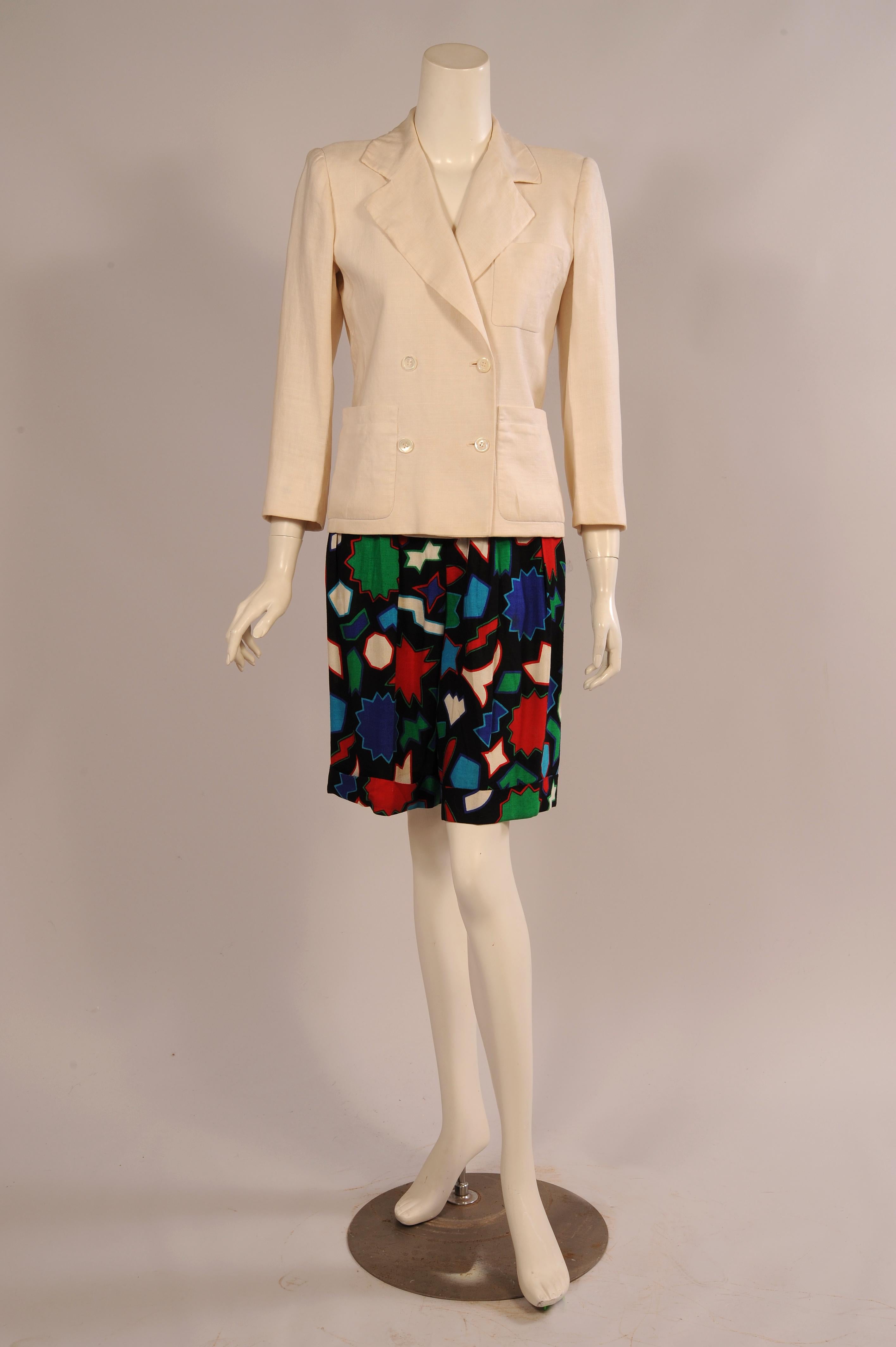 A classic creamy white double breasted linen blazer is paired with black linen shorts with brightly colored designs for a very chic summer suit. The jacket has a breast pocket and two hip pockets and it is fully lined. The shorts have a natural