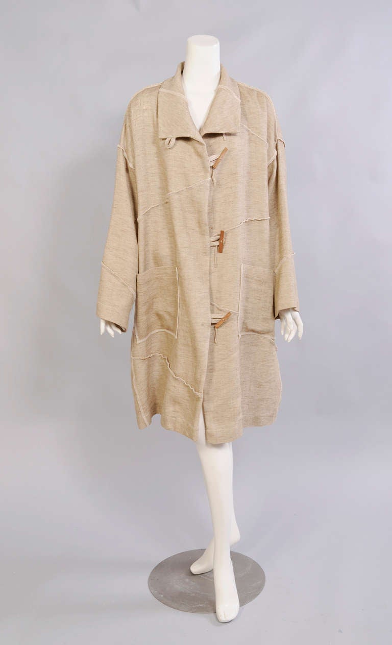 Kirsten Bernecker has designed a very modern take on the Spring coat. Pieced together with exposed, overcast seams this coat has four wooden buttons and fabric loops as well as two patch pockets. It is in excellent condition and appears
