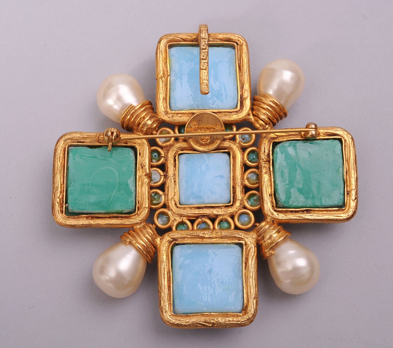 This stunning Maltese cross piece is so evocative of Coco Chanel and the jewelry she wore. It can be worn as a pin or as a pendant. Beautiful shades of blue and green poured glass are accented with large pearls and gold toned metal work. Worn once