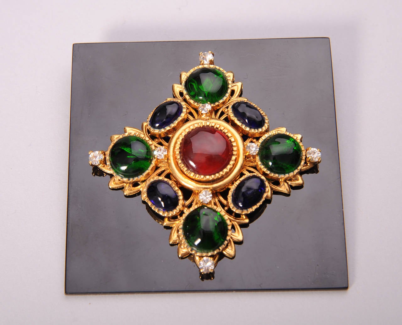 This gorgeous piece of Chanel Haute Couture jewelry is still pinned to the original backing. Gripoix stones in shades of deep green, red and sapphire blue are accented with smaller 