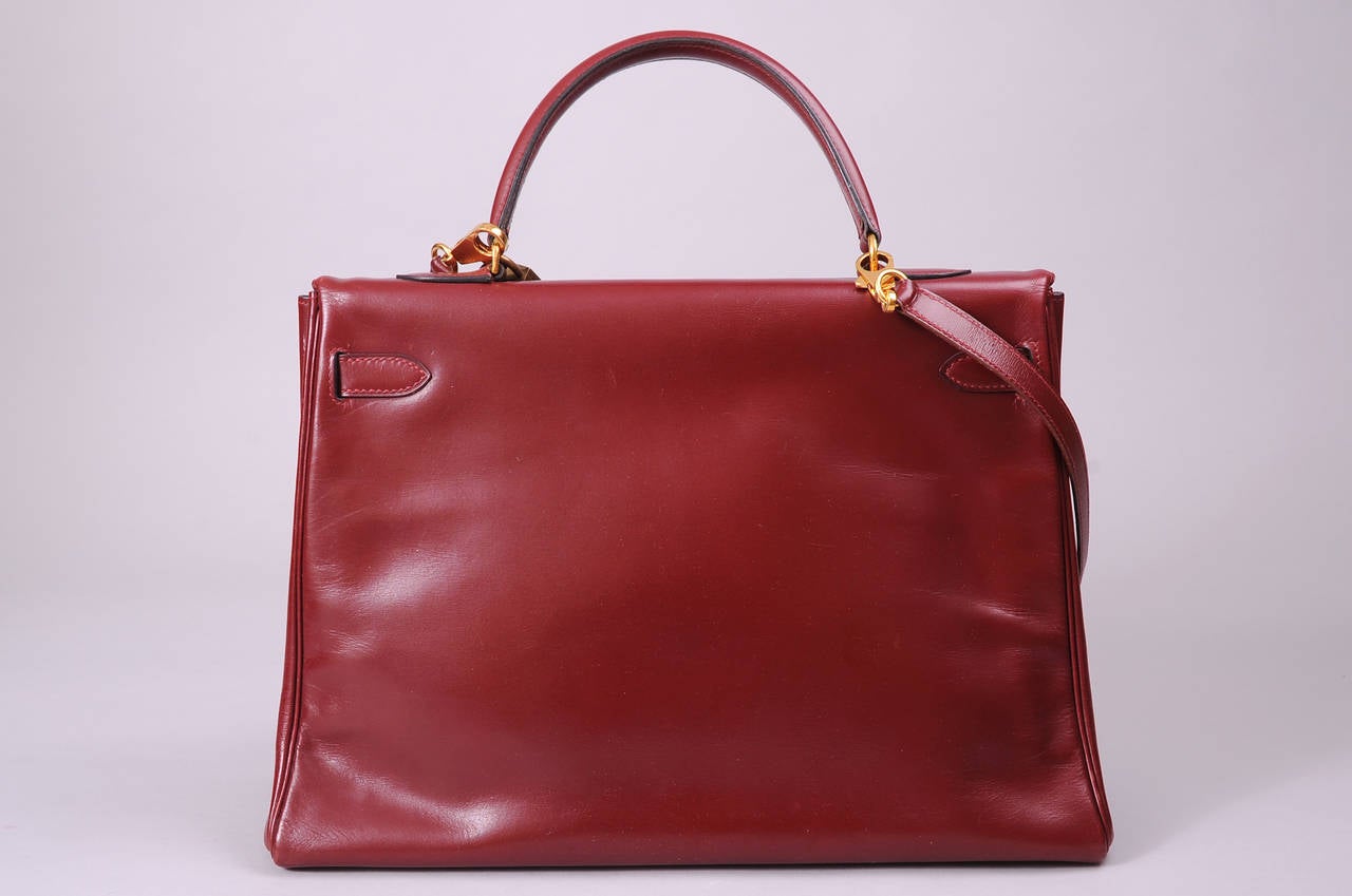 This classic 1979 Hermes Kelly bag in burgundy box calf comes with a matching shoulder strap, lock,  key and clochette. The bag is in excellent vintage condition and bears all of the correct Hermes marks. It is marked with an I in a circle for