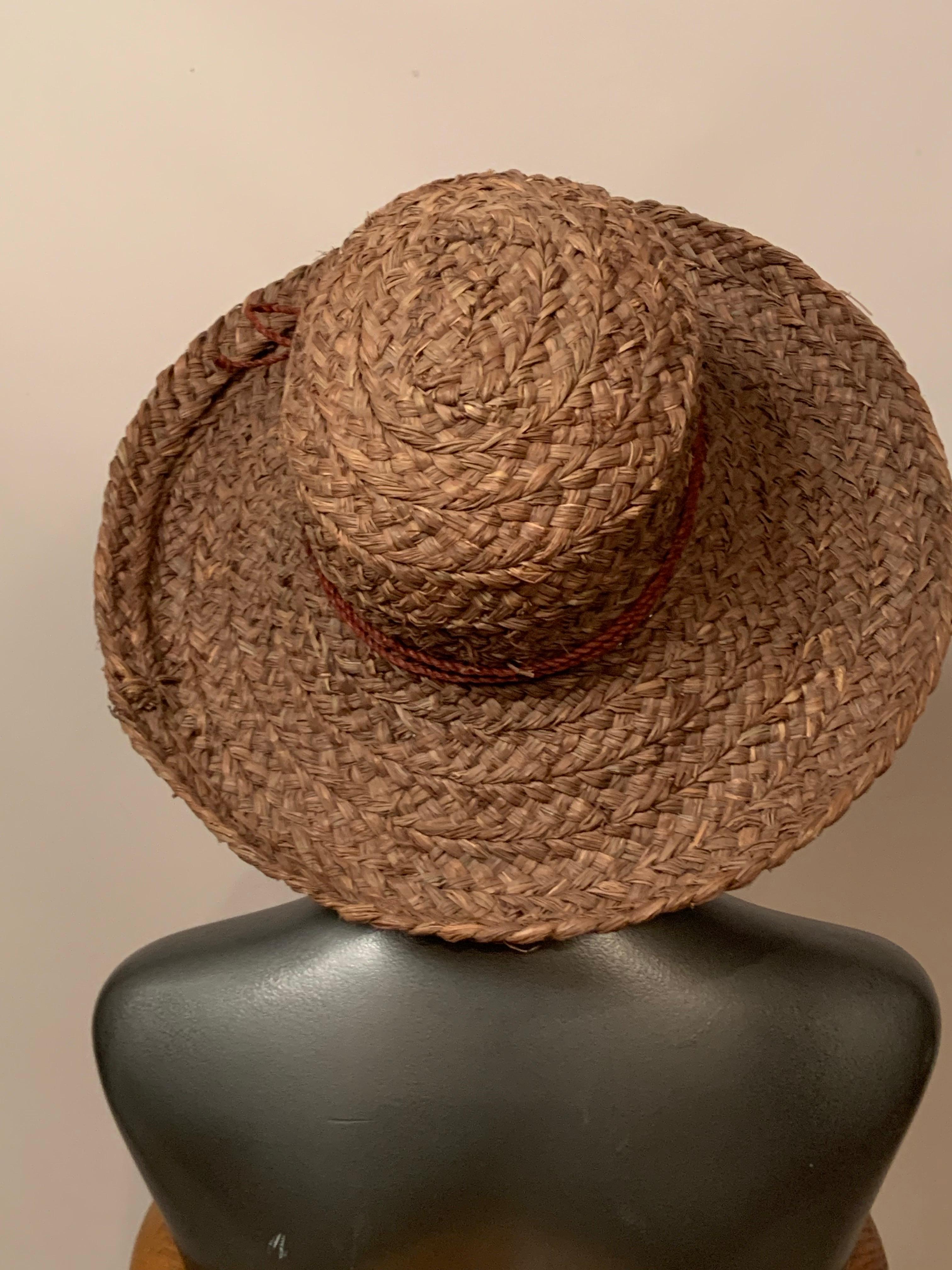 Questo cappello di paglia marrone cacao, disegnato in Australia da  Helen Kaminski è il cappello estivo perfetto. 
Ha una tesa generosa, che si alza su tutto il perimetro ed è rifinita con una fascia di paglia color cioccolato. Il cappello, che è