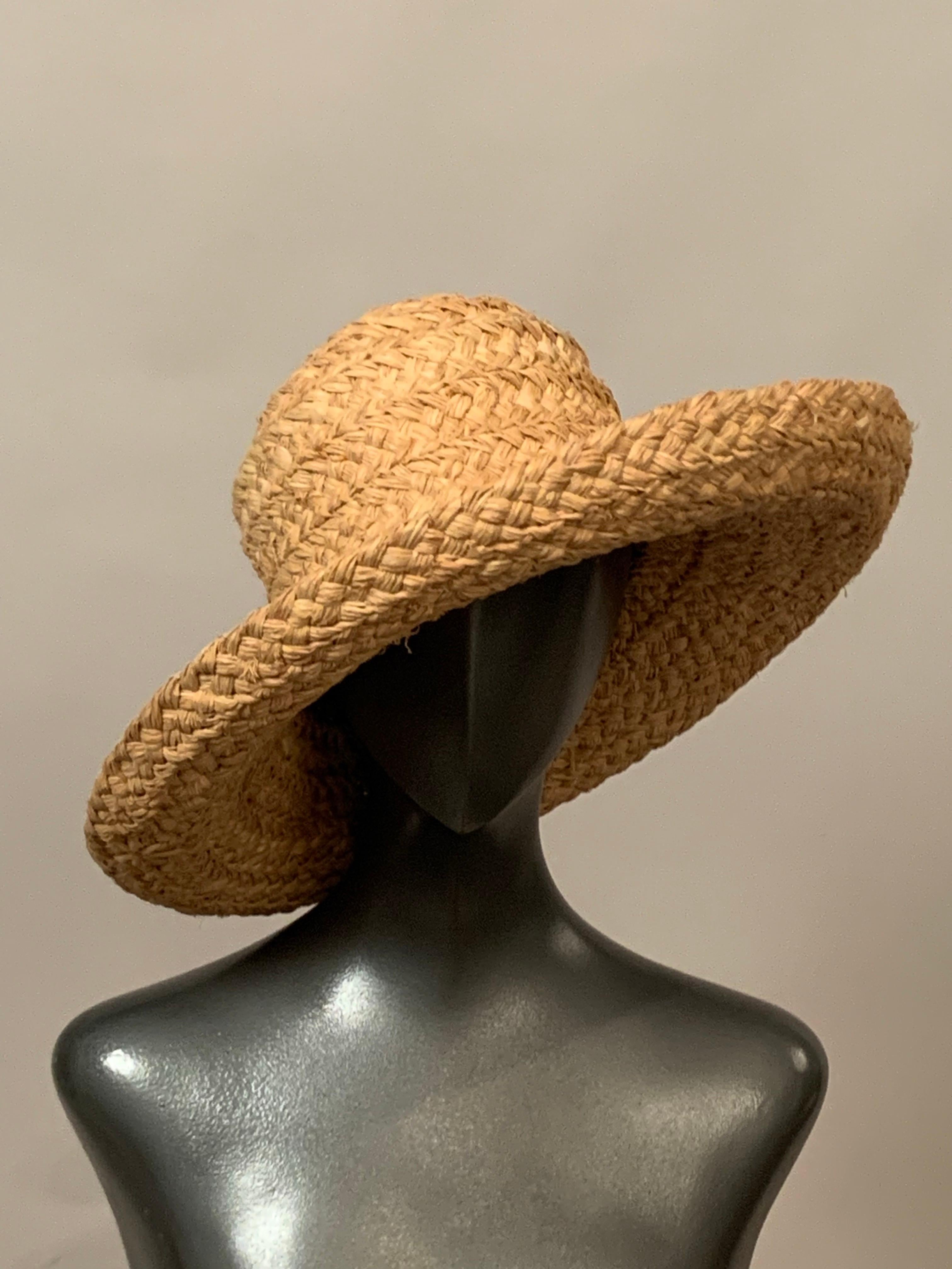 Questo cappello di paglia naturale abbronzato, disegnato in Australia da  Helen Kaminski è il cappello estivo perfetto. 
Ha una tesa generosa, che si alza su tutto il perimetro ed è rifinita con una fascia di paglia color cioccolato. Il cappello,