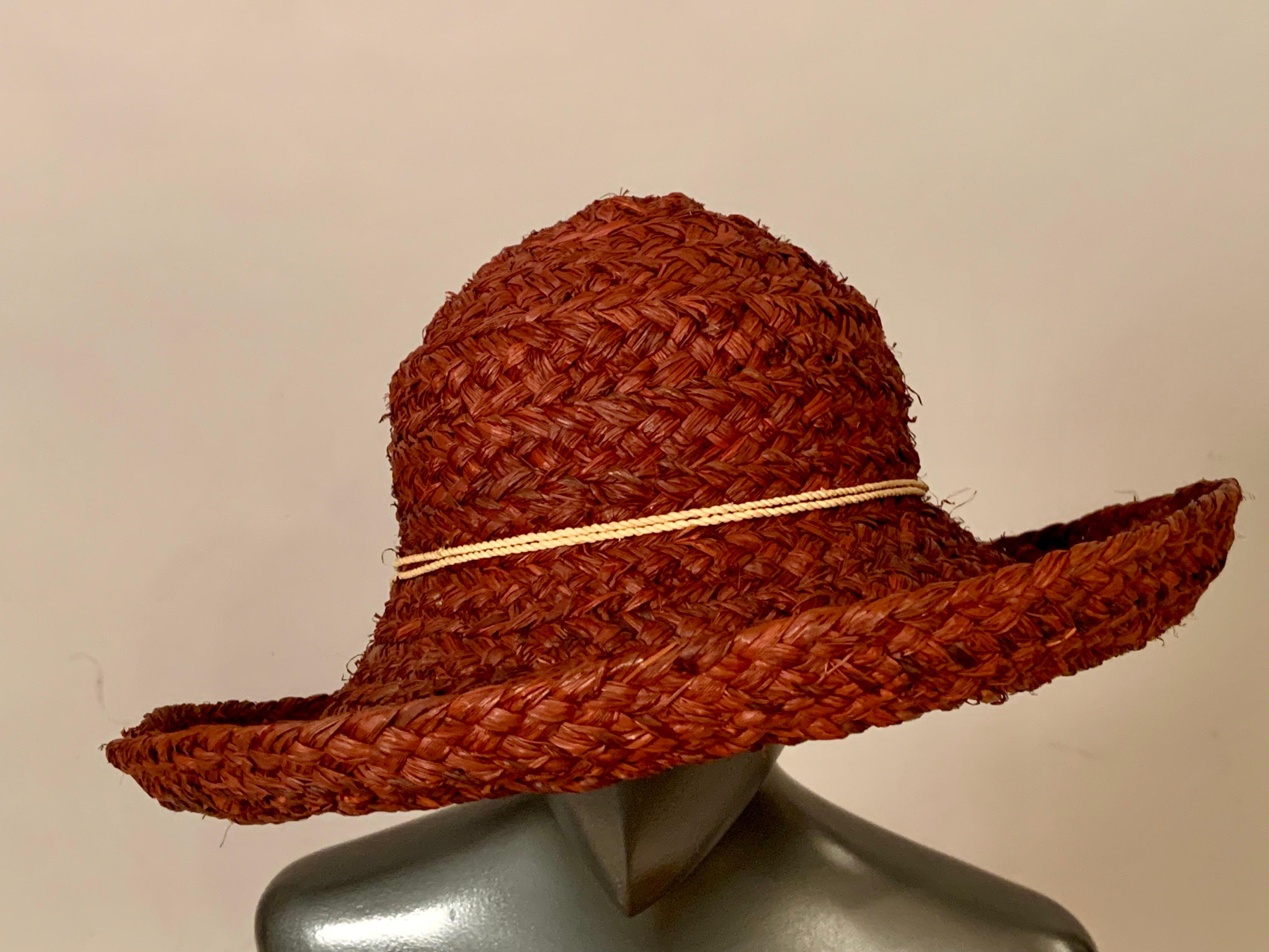 Questo cappello di paglia rosso è stato disegnato in Australia da  Helen Kaminski è il cappello estivo perfetto. 
Ha una tesa generosa, che si alza su tutto il perimetro ed è rifinita con una fascia di paglia color cioccolato. Il cappello, che è