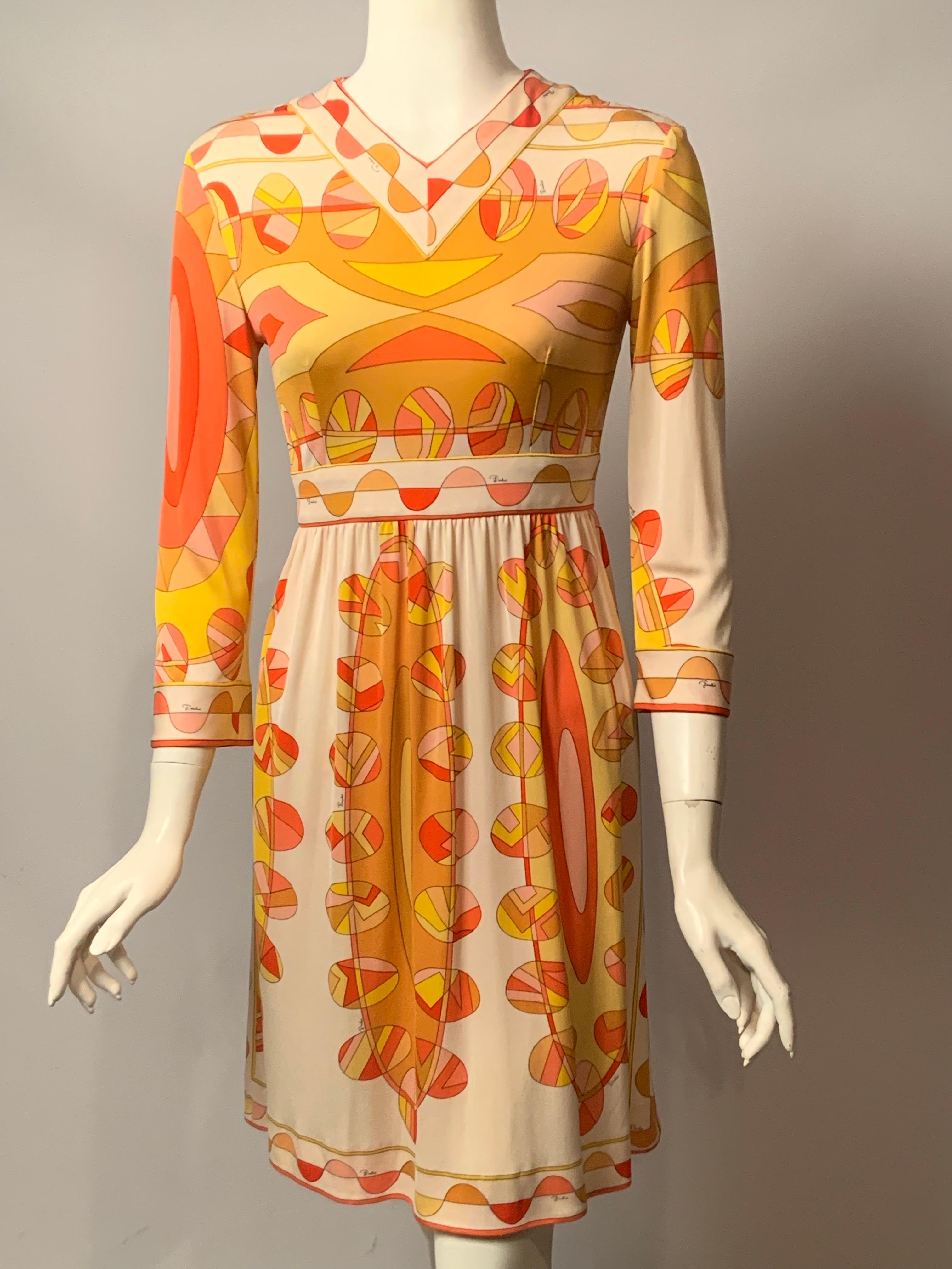 Emilio Pucci a conçu cette robe en jersey de soie dans l'un de ses imprimés emblématiques signés. La palette de couleurs est une combinaison très ensoleillée et joyeuse de jaune, de camel, d'orange et de rose sur fond blanc. L'élément de design en
