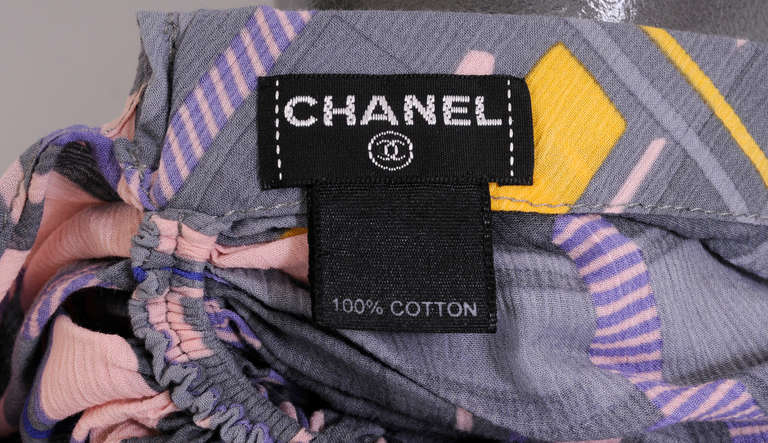 A colorful printed cotton is used for this chic summer head wrap from Chanel. It has an elastic band at the back of head, just above the loose scarf, for a snug fit. The Chanel label is inside and the metal dounle C logo is on one of the scarf
