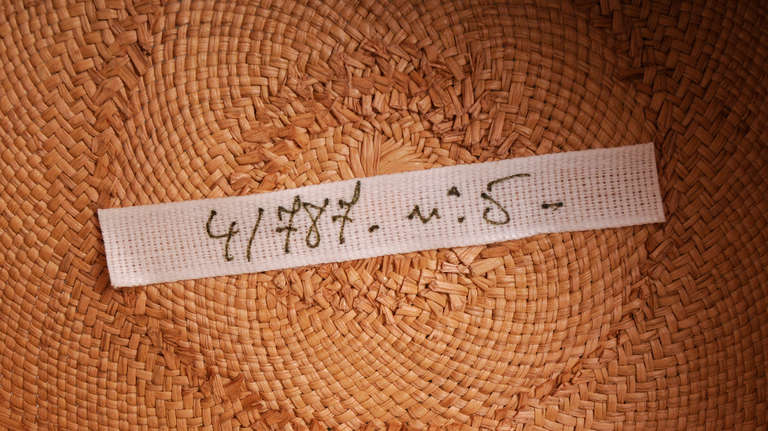 Runway worn, this fine quality, natural colored hand woven Panama straw hat has a high crown and a generous brim. The entire crown is wrapped in a supple olive green snake skin hatband.  The hat is in excellent condition and bears the numbered label