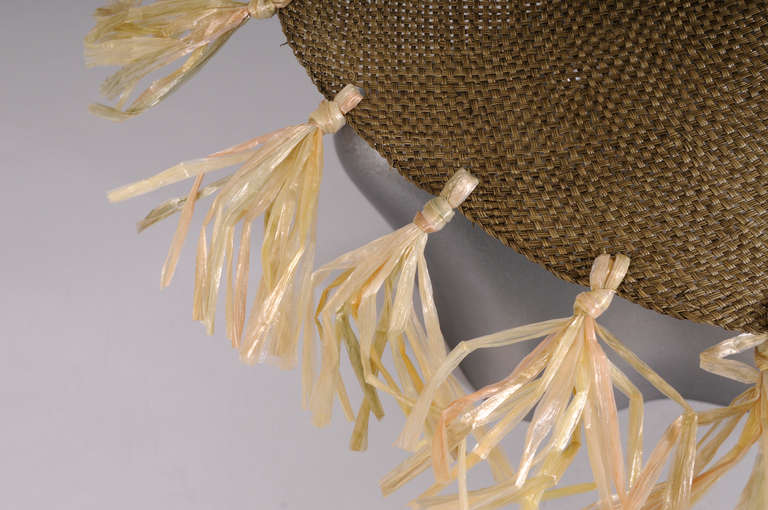 What a great summer hat!  Finely woven pale olive green straw is accented with cellophane fringe that is tied all the way around the brim. The hat is in excellent condition.
Measurements;
Height 4.5