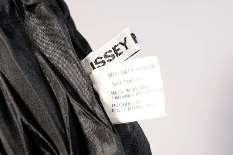 A diamond pattern pleated organza is accented  with a black cord drawstring and a black leather strap to create a distinctive evening bag from Issey Miyake.
Measurements;
Height 12