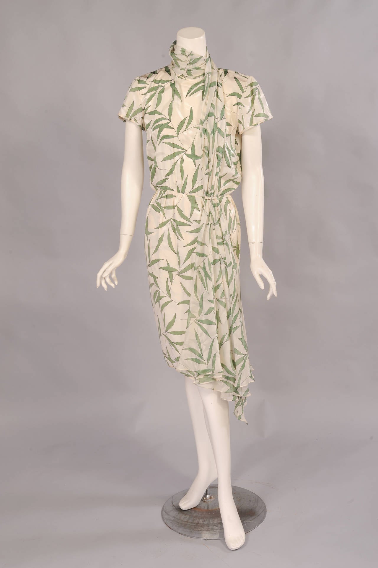 White  on white woven bamboo and green on white printed bamboo leaves are combined on this silk dress and the attached silk  chiffon that wraps and drapes
from the neckline to the hem of the wrap skirt. The dress has three buttons above an opening