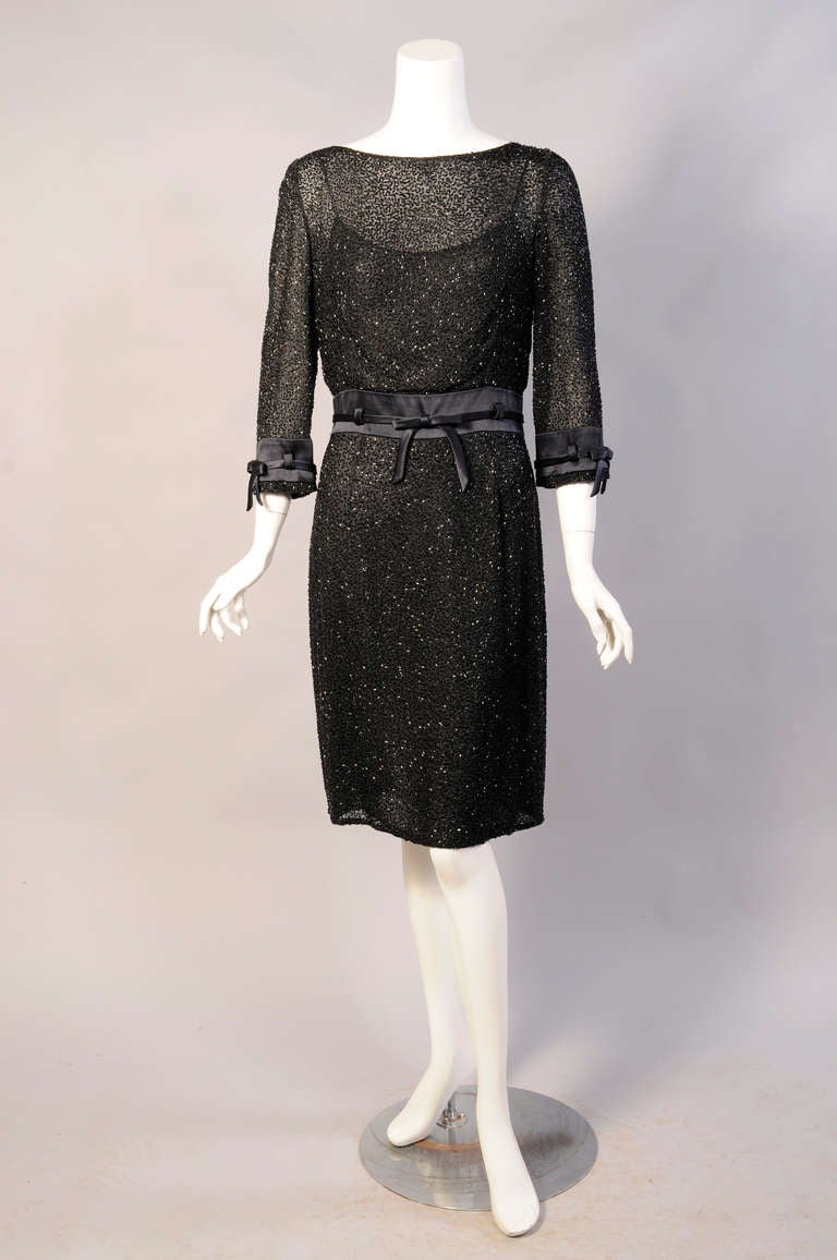 This dress from the masters of evening attire, Badgley Mischka, is inspired by designs from the early 1960's. Their interpretation of this look is thoroughly modern. The dress is covered with black bugle beads in a vermicelli pattern on sheer silk