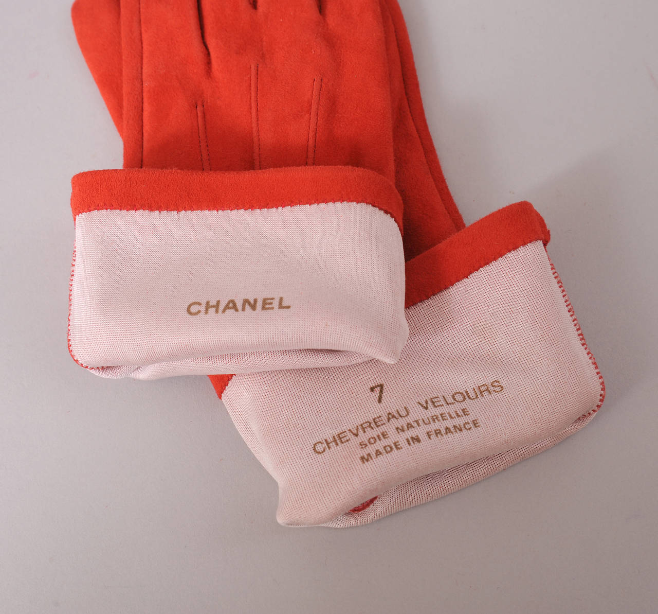 The perfect pop of color, these orange lamb suede gloves will enliven any look. They are lined in silk and marked a size 7. They are in pristine condition.