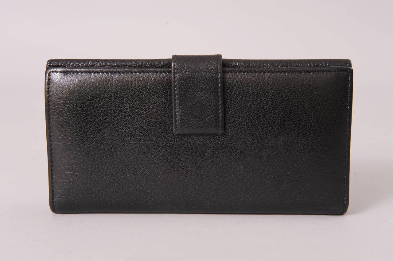 Supple black leather is decorated with an applied black leather Gucci logo studded with gold toned balls. Generous sections for bills, change and credit card make this a well designed wallet. It is in excellent conc=dition.
Measurements;
Height