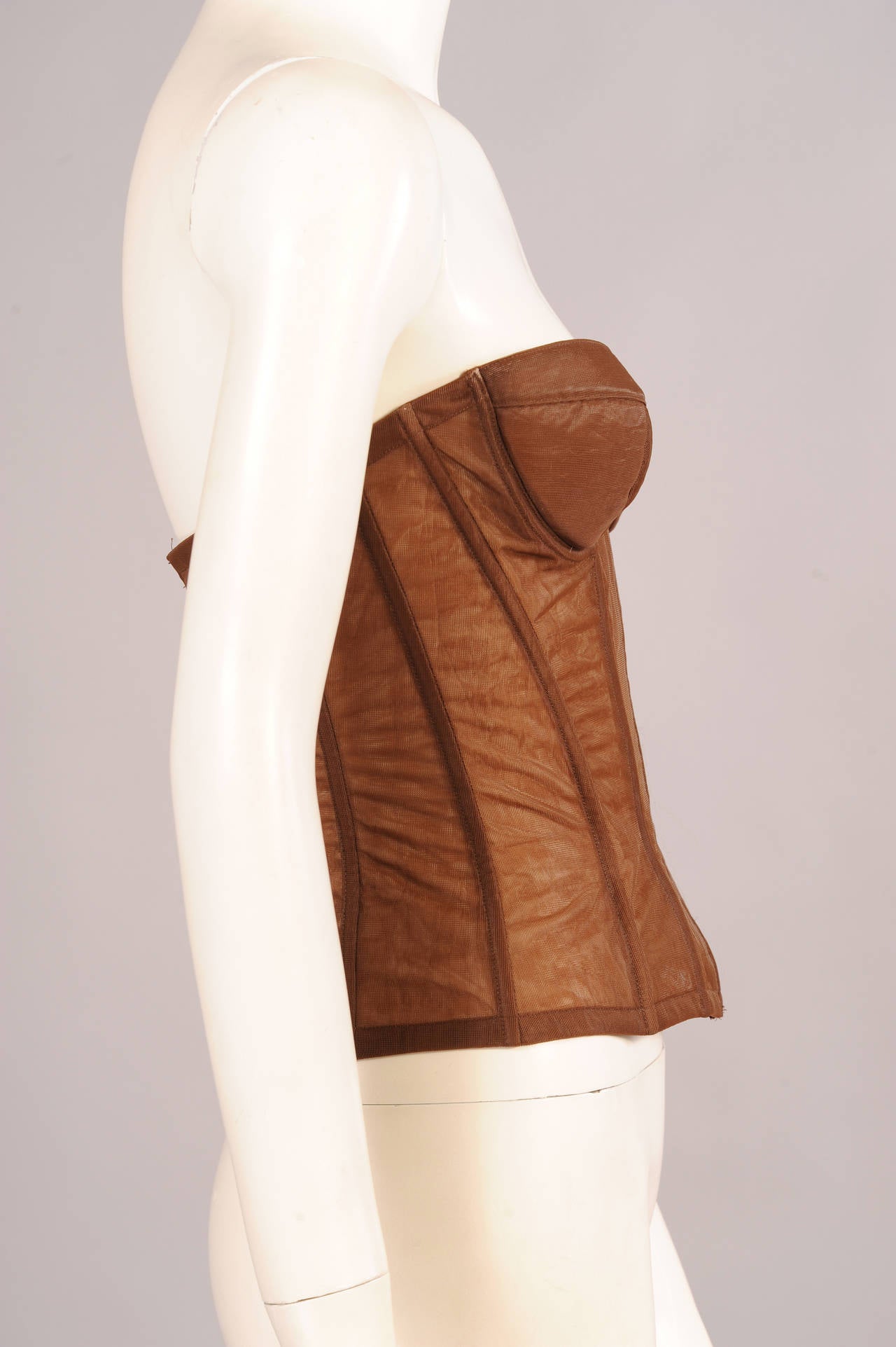 This flesh tone bustier was worn on the Chanel Haute Couture runway by a model named Beverly, probably supermodel Beverly Johnson. It has a center front zipper and lightly padded, silk lined, underwire cups. The center back panel is made from a