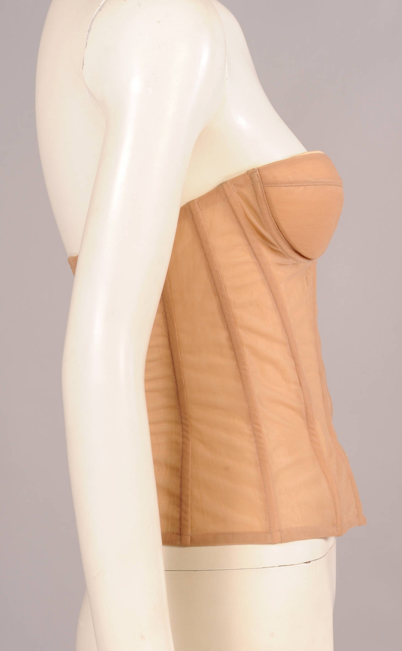 This nude bustier was worn on the Chanel Haute Couture runway by the model Chrystelle. it has a center front zipper and lightly padded, silk lined underwire cups. The center back panel is made from a stretch fabric. It is in excellent