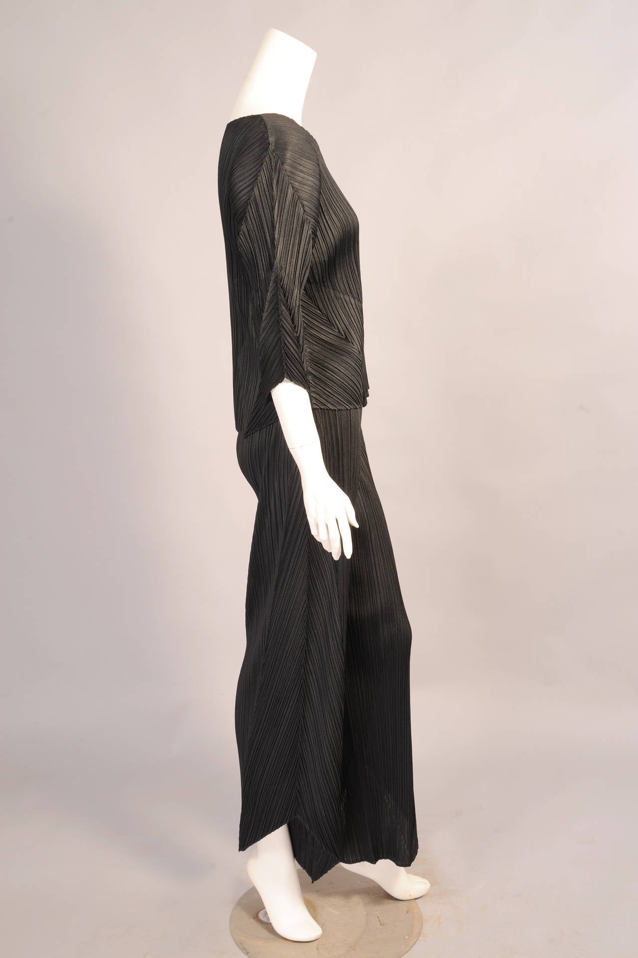 Issey Miyake designed this two piece ensemble for his Pleats Please line. Arrow shaped panels add interest to the sleeves and front. The pants have an elasticized waist. Both pieces are in excellent condition.
Measurements;  Not stretched
Top
Bust