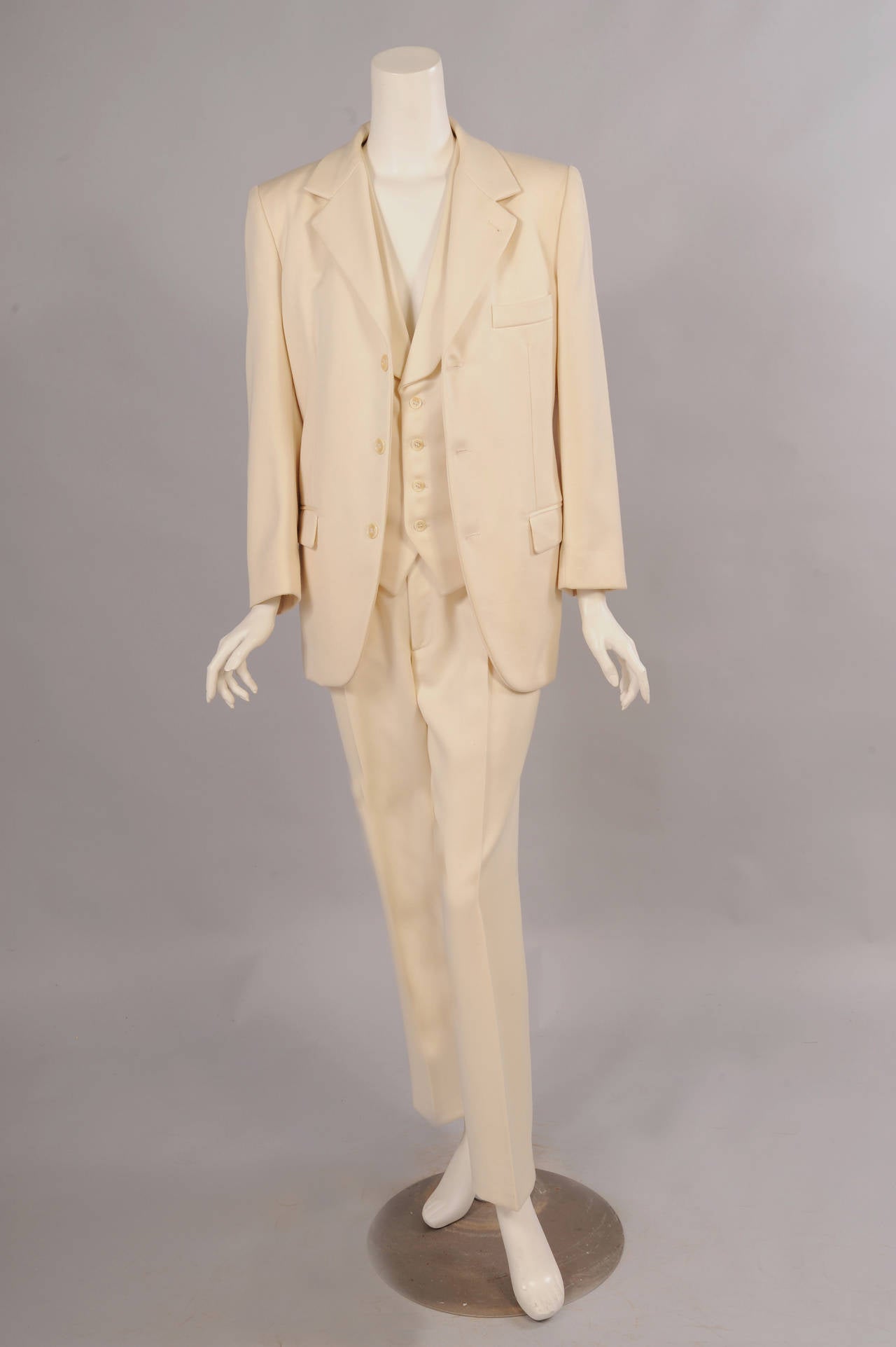 A gorgeous cream wool suit that is tailored for a man but would look equally chic on a woman was worn n the runway. The three button jacket has notched lapels, a breast pocket and two hip pockets. There are four interior pockets as well. The vest