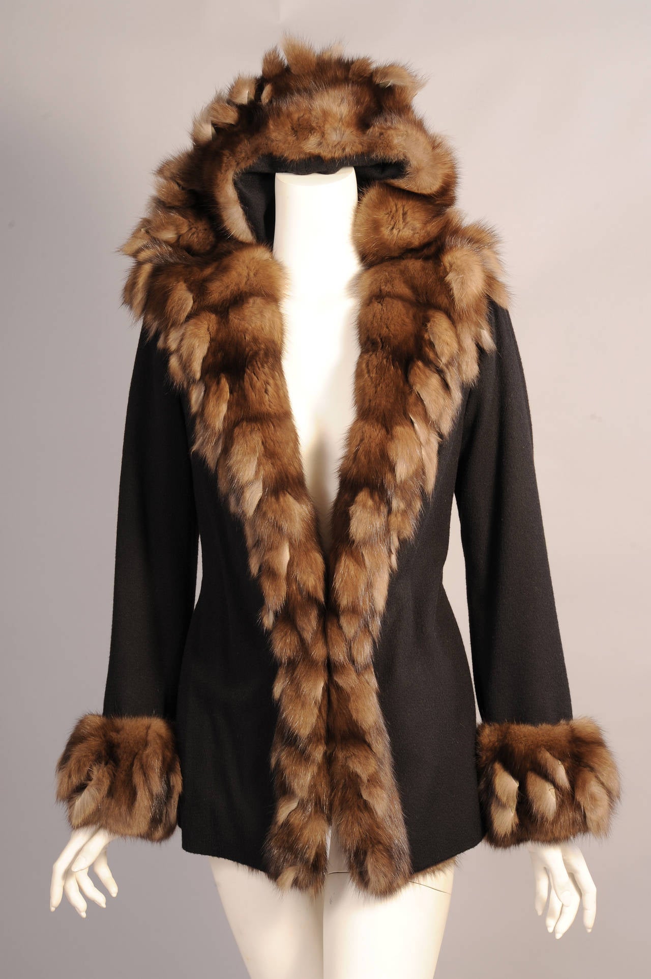 Carlo Tivioli an Italian furrier has trimmed this hooded black cashmere jacket with a wide band of luxurious sable.This is trimmed with a fringe of sable pieces for a modern look. The jacket has two pockets. apeplum in back and it is fully lined in