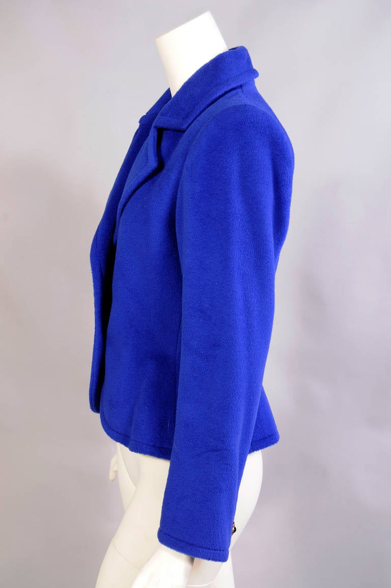 A bright blue cashmere and wool blend fabric, in a winter weight, is trimmed with three jeweled buttons for a perfect day or evening jacket. It is fully lined in a matching blue silk and hand finished in the couture manner. It is in excellent