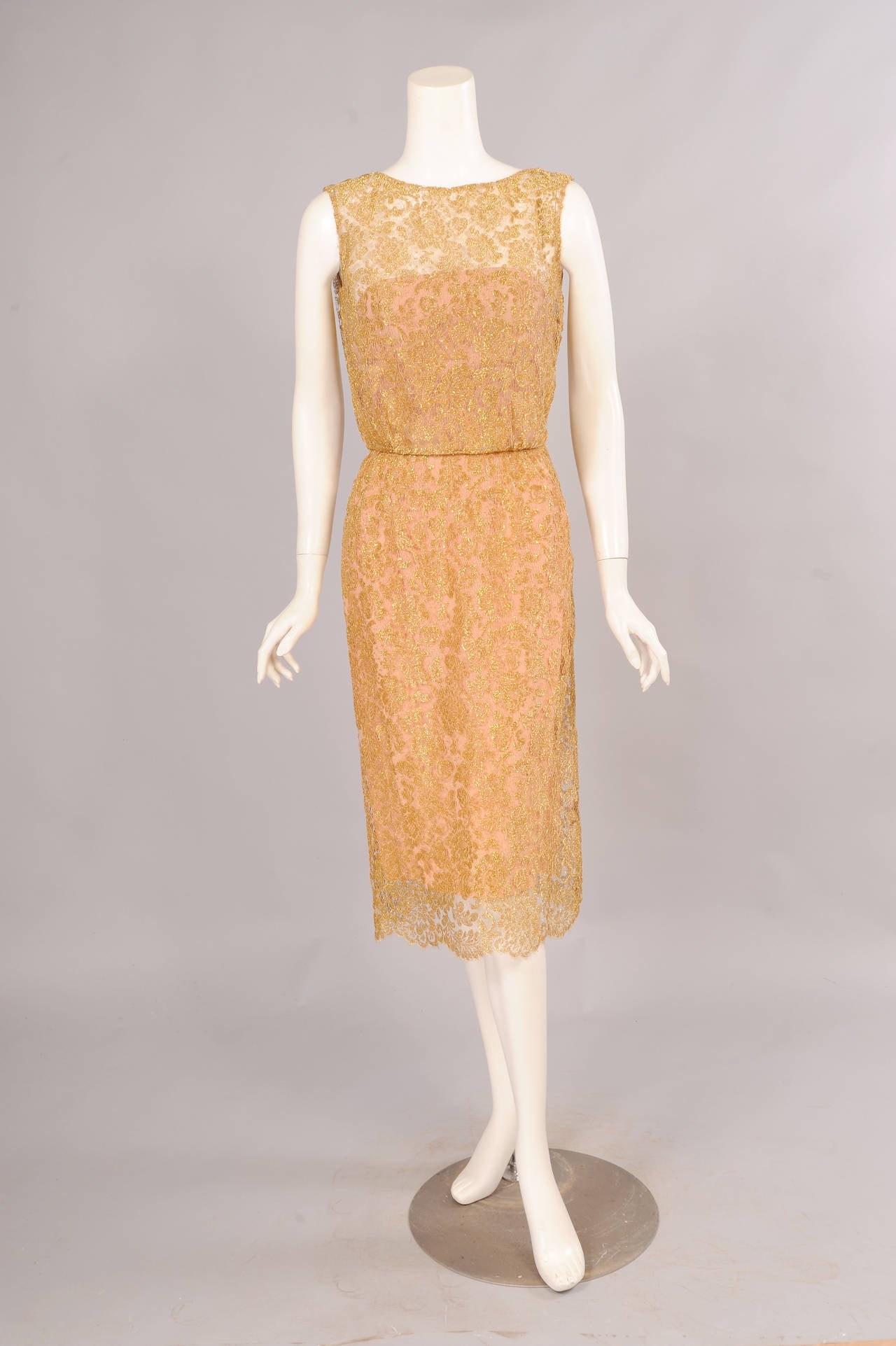 Beautiful gold lace is lined with a rose pink silk strapless sheath creating the look of a rose gold evening dress. The dress opens on the left shoulder and side with hooks and eyes, snaps and a zipper. It is in excellent