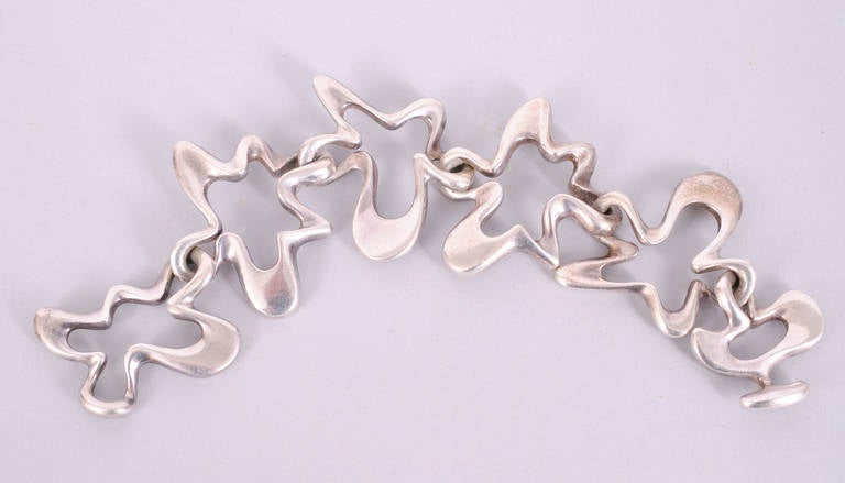 Mid-century design at its best, this fabulous Amoeba bracelet from Danish silversmith Georg Jensen was designed by Henning Koppel in 1947. The stamp indicates that it is signed and dated for 1947. It is in excellent condition.