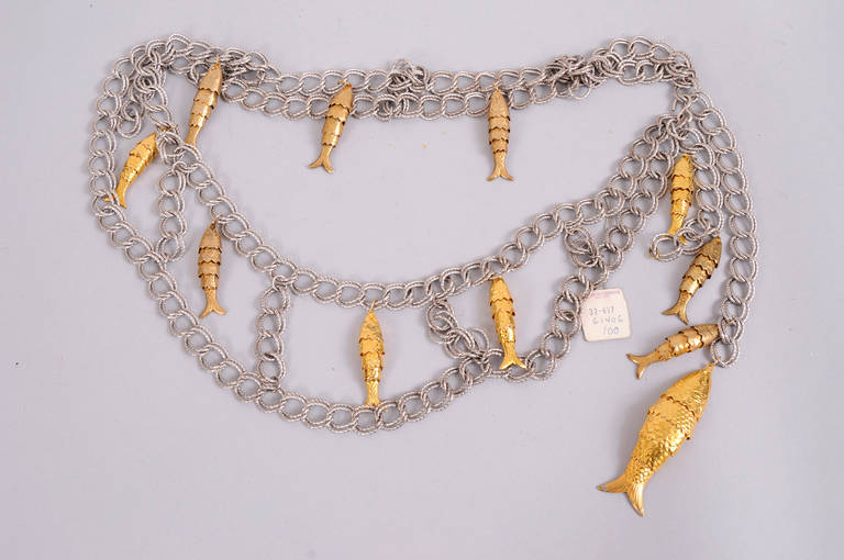 A silver tone double  link chain is enlivened with articulated gold tone metal fish. Each section of the belt showcases a fish and there are two on each end of the belt. Never used, with the original price tag, this piece is in excellent
