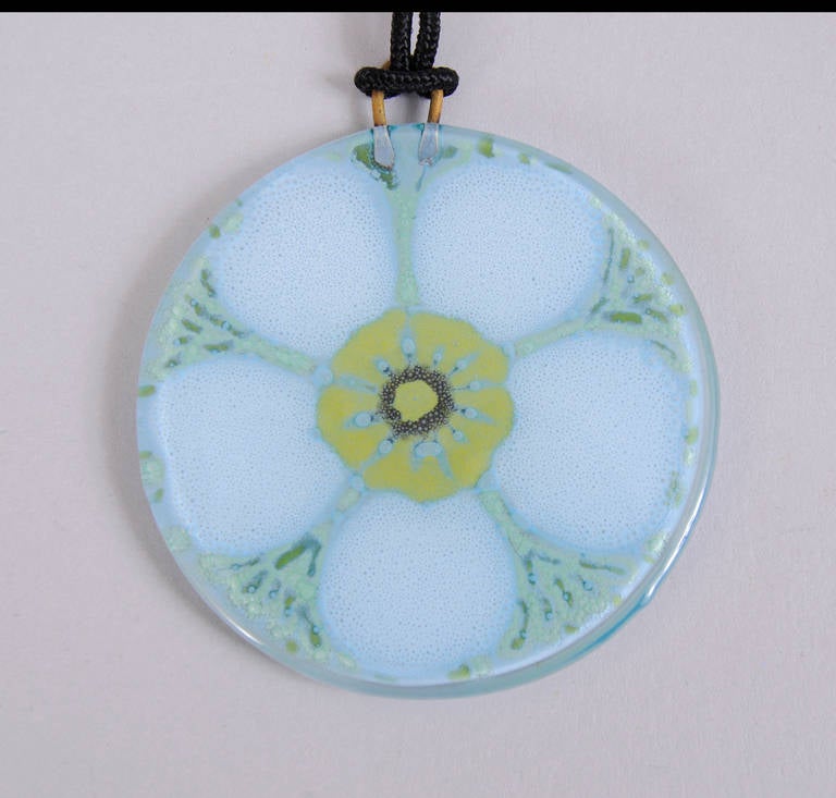A charming floral design, so evocative of the 1970's is the motif for this Higgins pendant. The front is smooth, the matte glass back is signed Higgins.  It is in excellent condition.
Measurements;
Pendant 2 1/4" diameter
Cord 28"