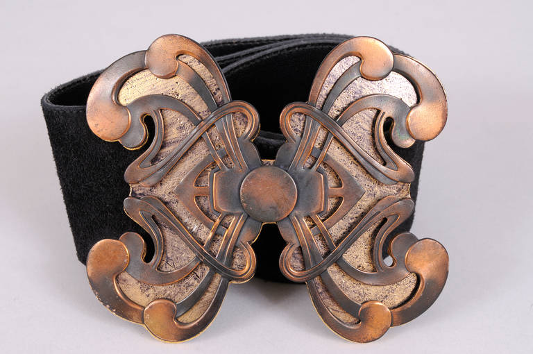 An Art Nouveau inspired copper design piece is attached to a gold toned metal backing creating a stunning belt buckle. The wide black suede belt is adjustable for length and it is in excellent condition.
Measurements;
Belt
Length adjustable to