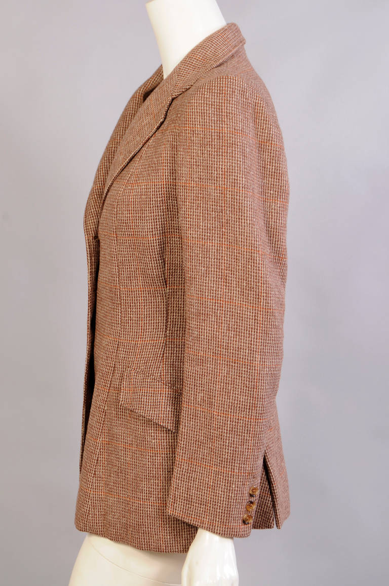 Brown and cream wool with a subtle rust colored stripe is used for this classic 1970's English riding jacket. Notched lapels, a three button closure, hip pockets and two back vents are some of the details in this jacket. The tan lining is hand