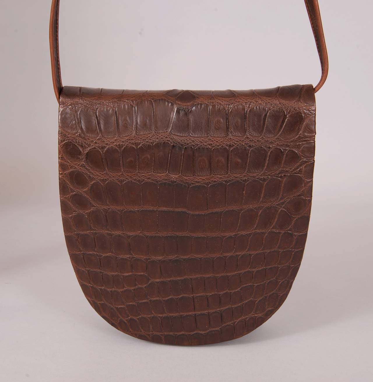 The exterior is matte brown crocodile, the interior flap and sides are buttery soft brown leather, and the interior of the bag is pristine beige suede. The slip pocket retains the original paper wrapped mirror, This bag is in excellent condition and