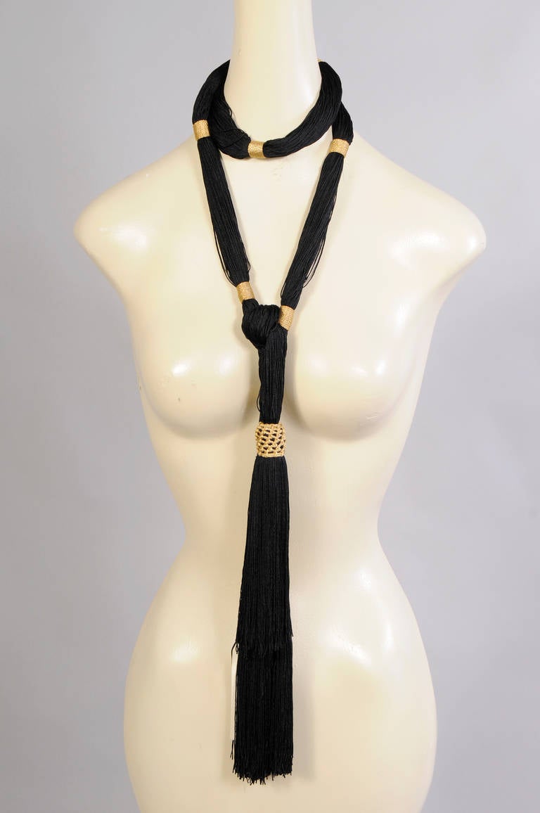 Fine black silk cord is wrapped in metallic gold thread to create a striking belt with big tassels. The tassels are decorated with gold lattice trim. It still retains the original tags and is in excellent condition.
Measurements;
Length 70