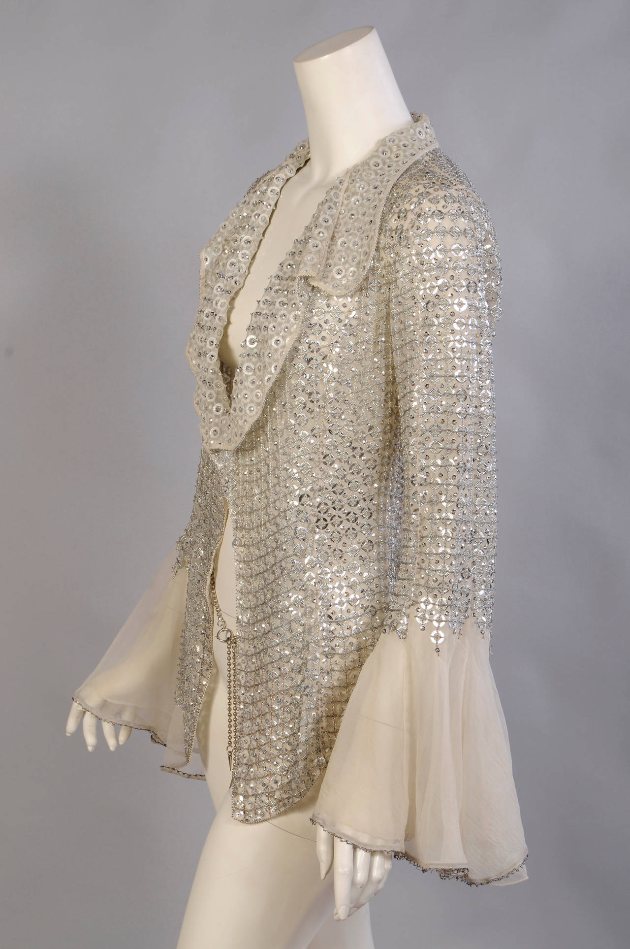 This silk organza jacket is lavishly beaded with silver sequin rings, small silver sequins and caviar beads. A delicate lattice of silver beadwork overlays the beaded design. The wrong side of the collar, lapels and front facings are also beaded