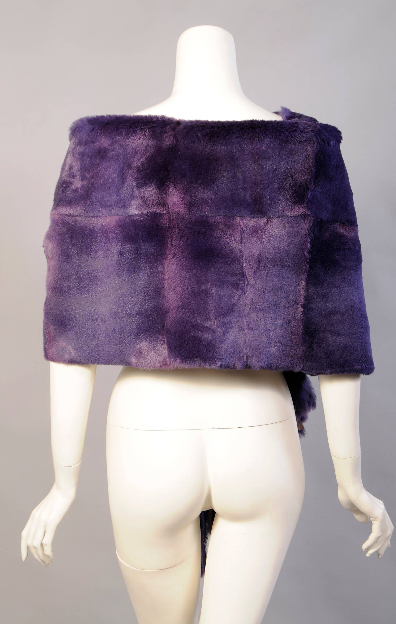 Light weight and luscious this purple shearling wrap from Gianfranco Ferre can be worn in a variety of ways. One side is deep purple shearling and the other side is lavender leather. Both ends have a deep fringe and it is in excellent