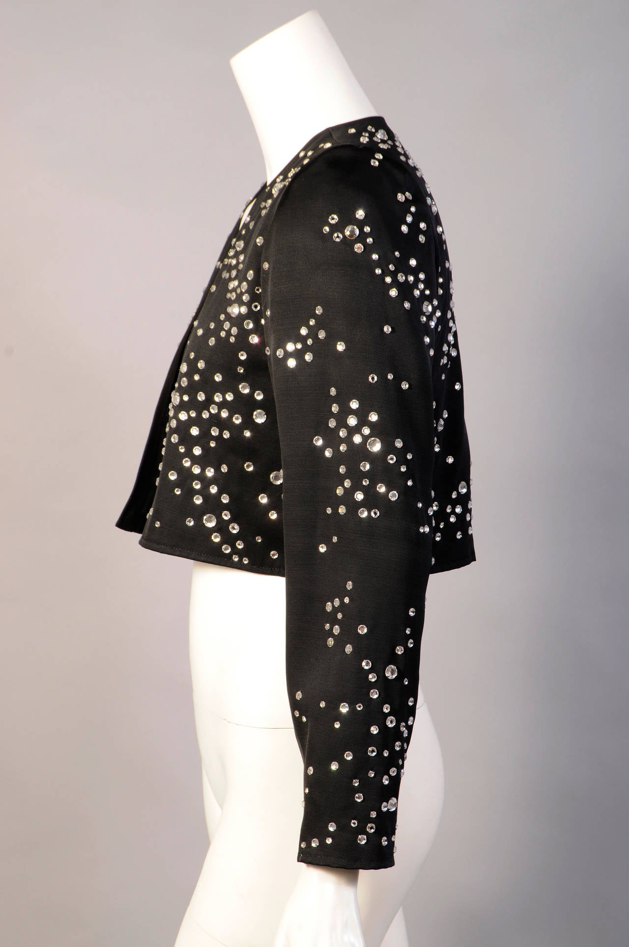 Prong set rhinestones are liberally scattered over this black silk faille jacket from Yves Saint Laurent. They are the only ornamemtation on this jewel of a jacket. It is in excellent condition.
Measurements;
Shoulders 13