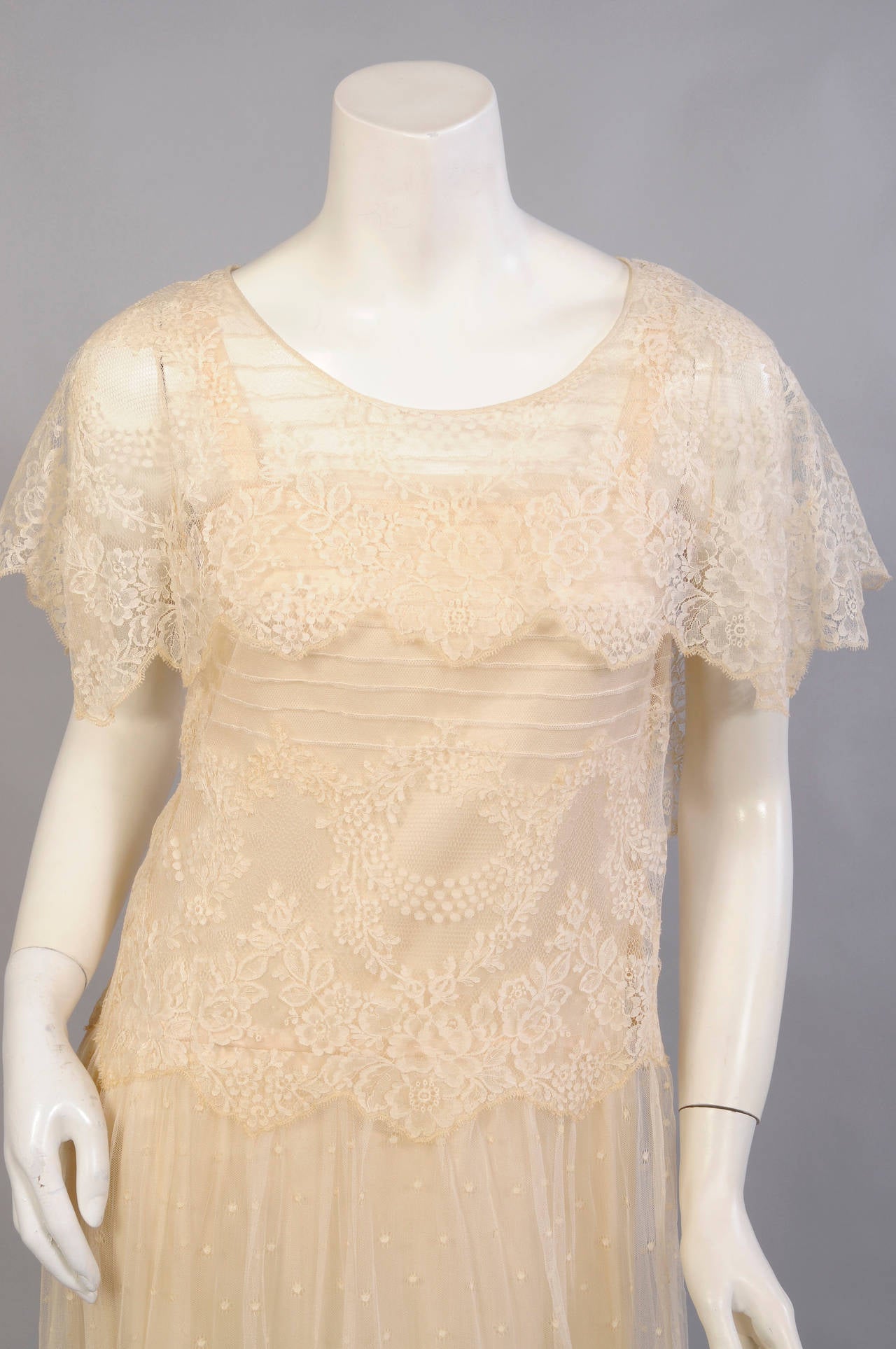 A gorgeous ivory silk charmeuse slip with French seams is the base for this ethereal lace dress.  The bodice is pin tucked horizontally with a large lace collar, dipping to the waist in back. The waist line incorporates the scalloped edge of the