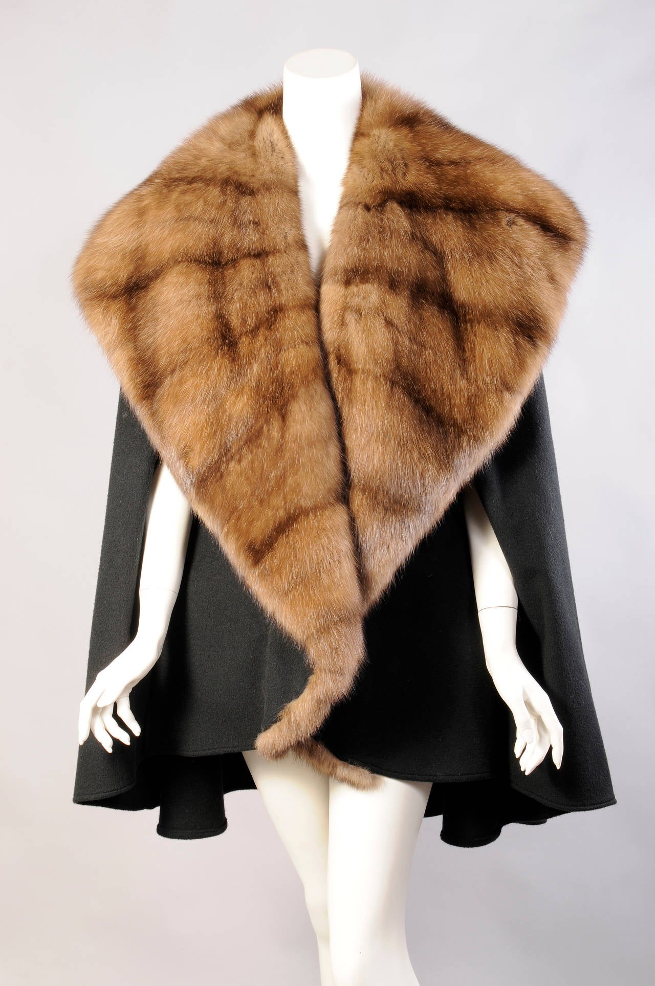 A generous Russian sable collar reaches all the way to the hemline on this double faced black cashmere wrap retailed by Bergdorf Goodman. There are two openings for your hands to wear it as a cape, or you can toss it over your shoulder as a wrap. It