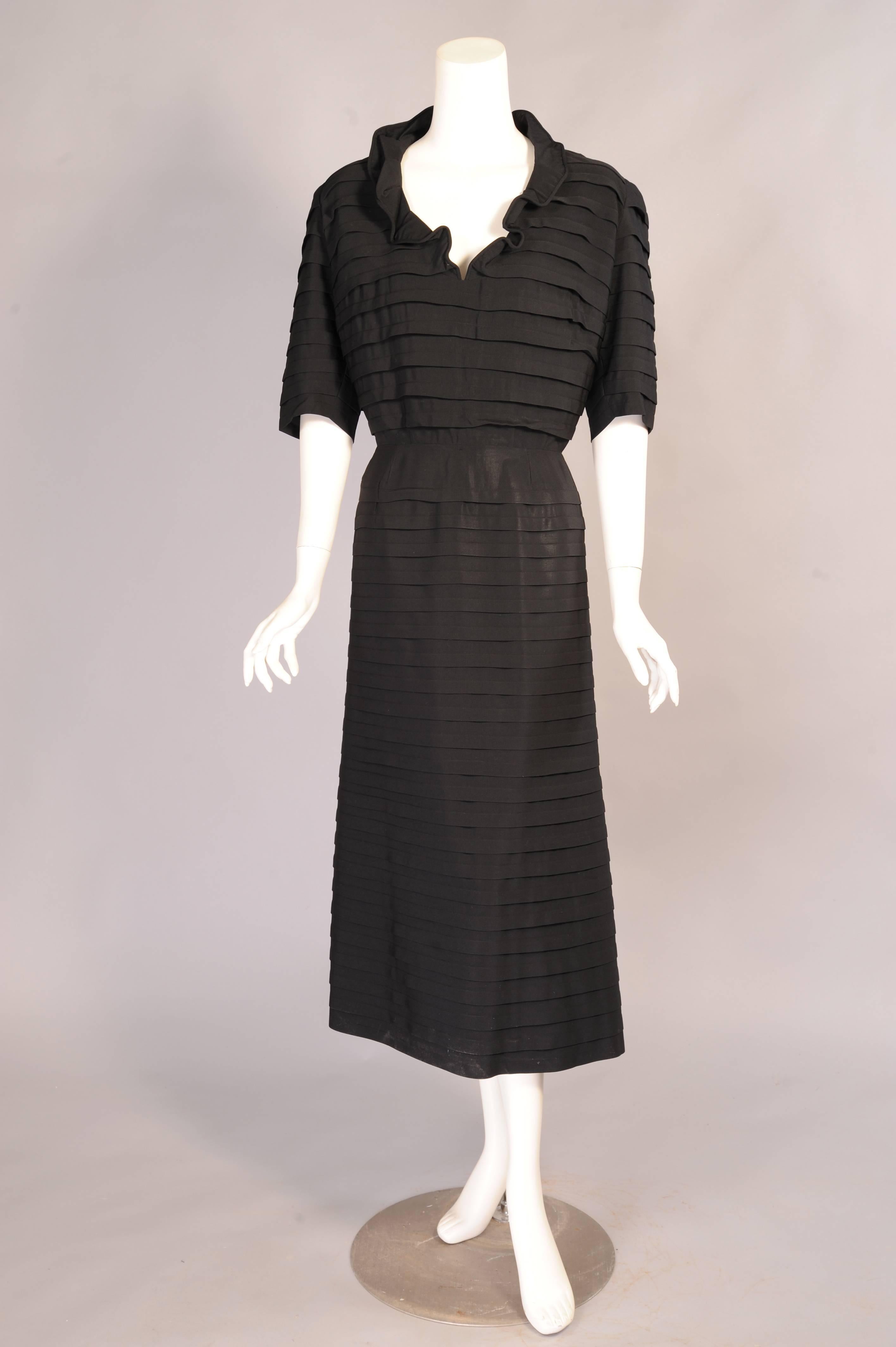 This is a French couture dress from the estate of an American lady who fell in love with and married an Italian Count in the 1950's. The black silk crepe dress is pleated from the shoulders to the hem, but the best part is the way in which the