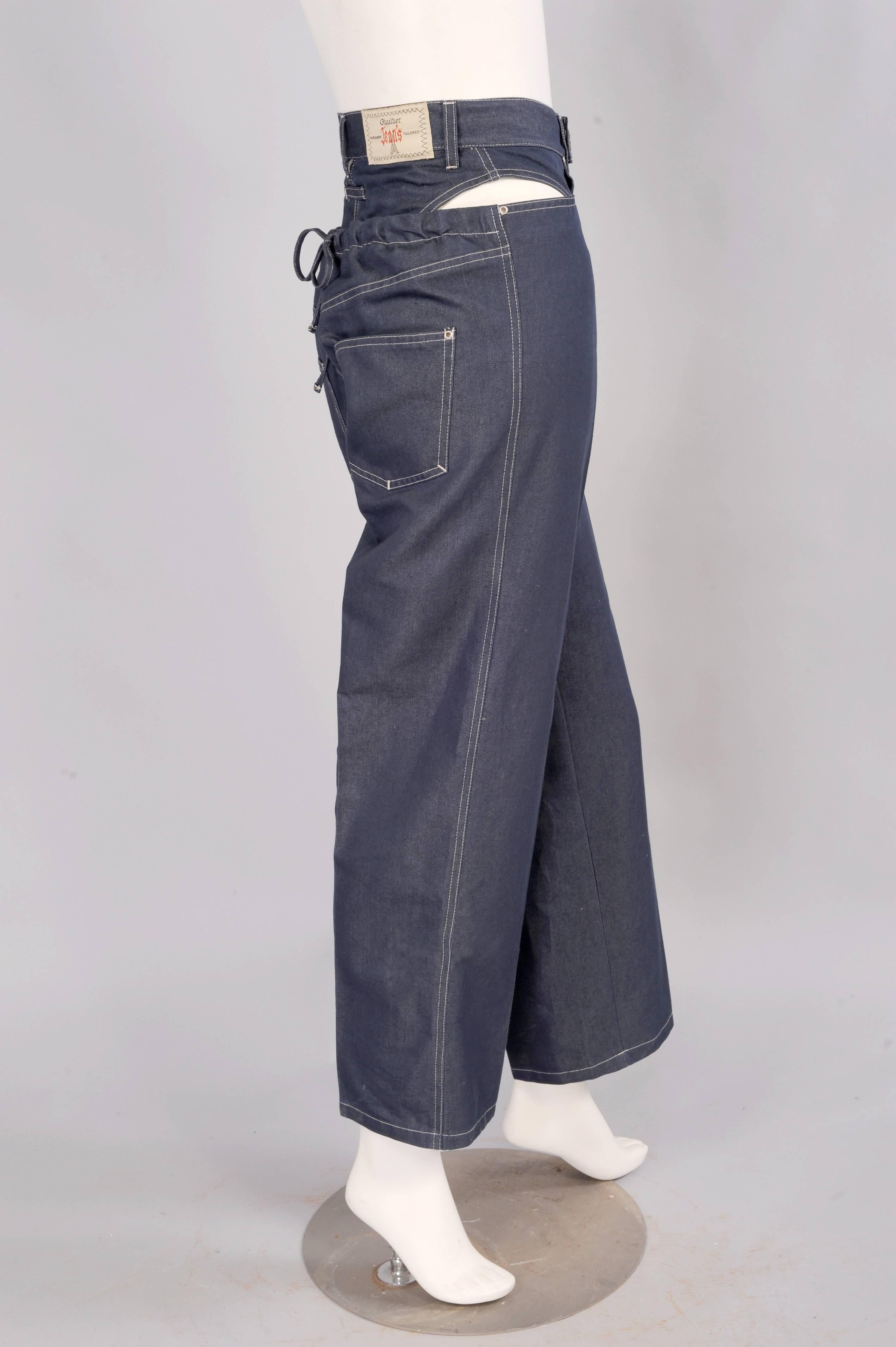 These straigh leg jeans are anything but straight laced. The classic style of the fly front jean is altered by removing the fabric over the hips and adding an almost separate bikini bottom. The back of the jeans are cut  low with a drawstring to