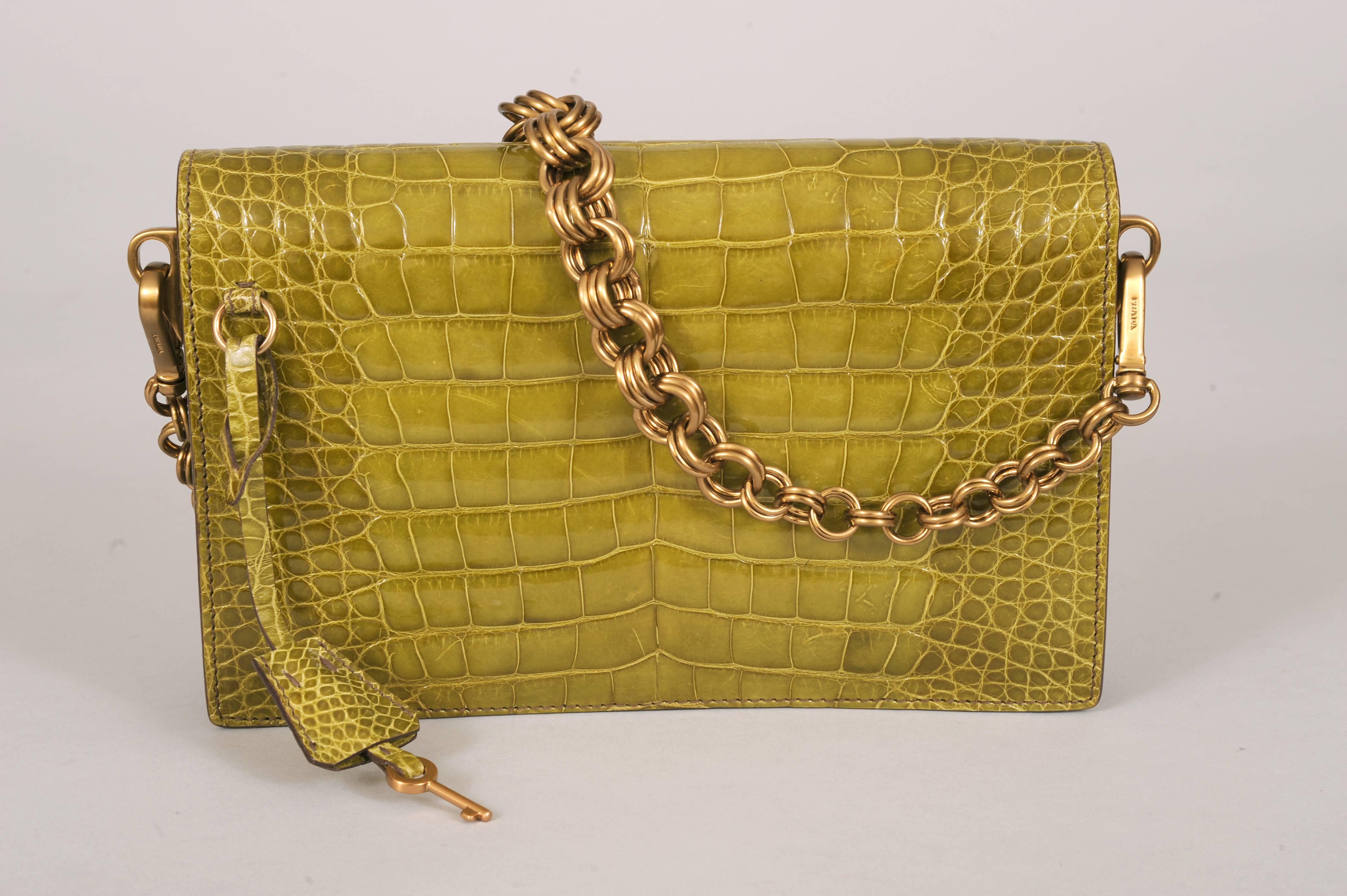 What an unusual color for an alligator bag! This rich olive green gator bag is so stylish. You can carry it by the chain strap or remove the chain and carry it as a clutch. The bag has a gold toned closure with a lock and key in a matching clochette
