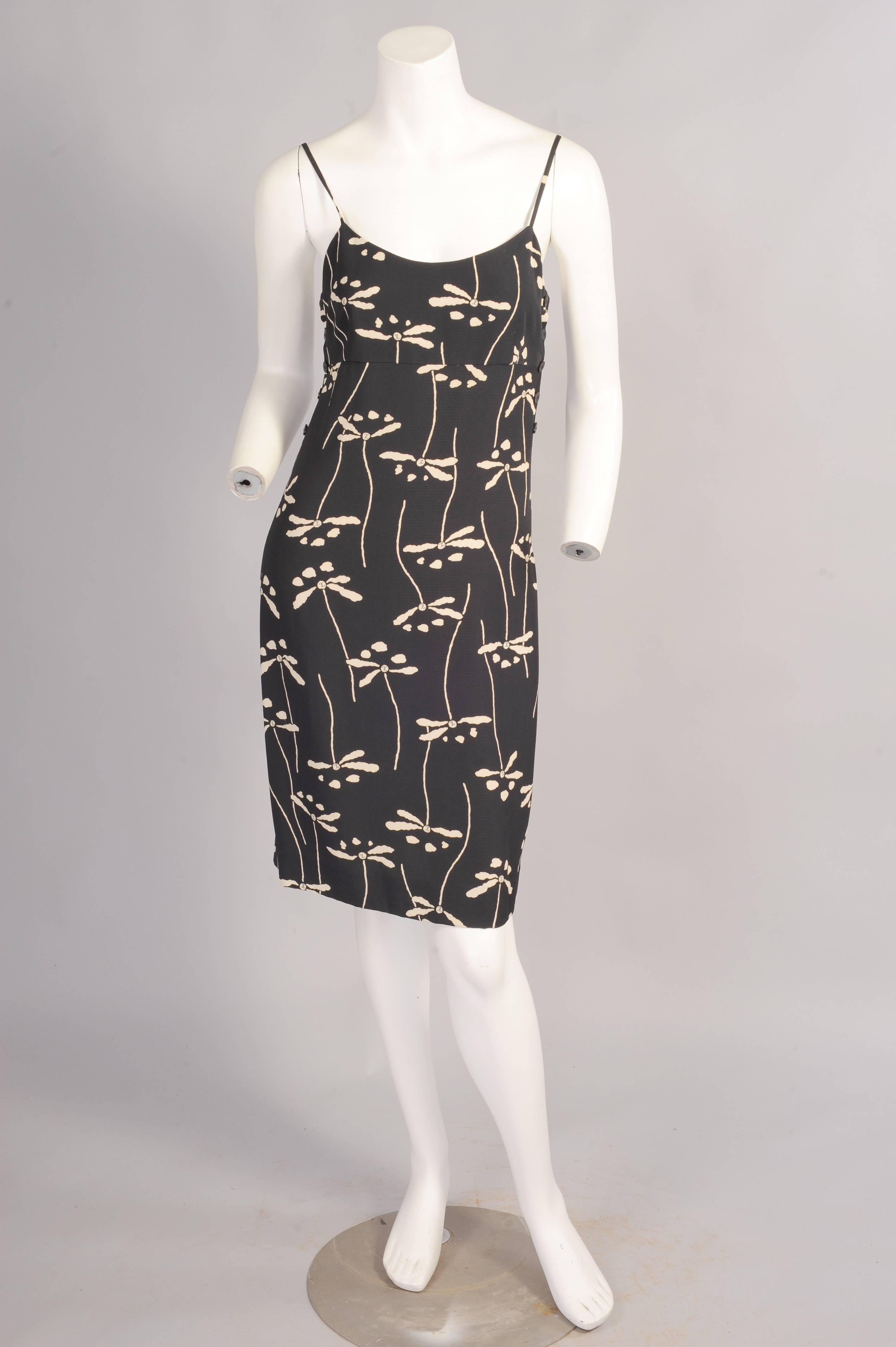 A charming black and cream dragonfly is enlivened with the chanel double C logo in the pattern. The dress has spaghetti srtaps and it buttons on each side to the waist. There is an invisible center back zipper. The dress is in excellent condition.