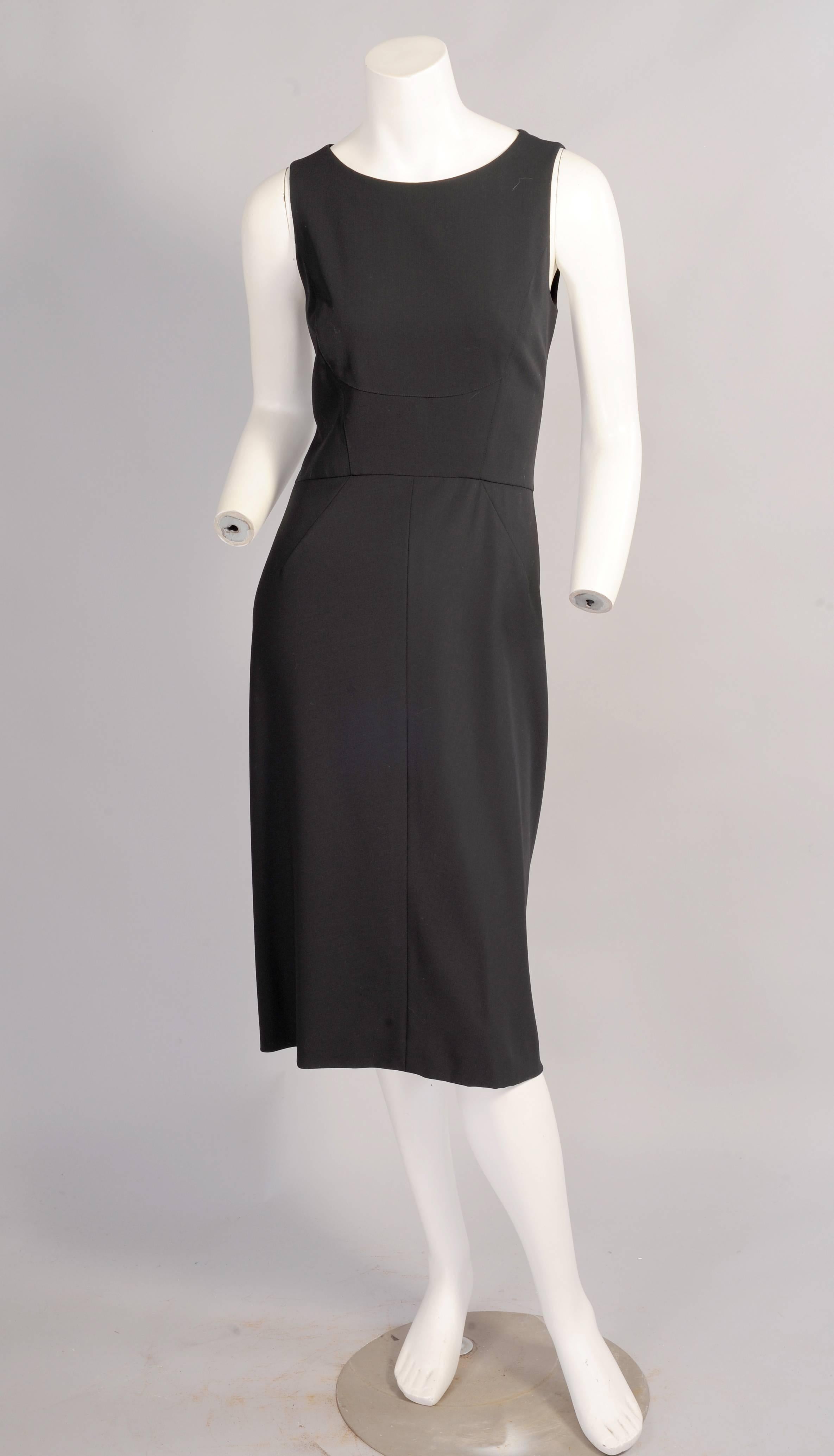 A fine light weight wool crepe is lined in black silk for this elegant dress from Chanel Boutique. Angled seams on the bodice and skirt add interest to the front. The skirt is pleated and stitched at the center back for an architectural look. This