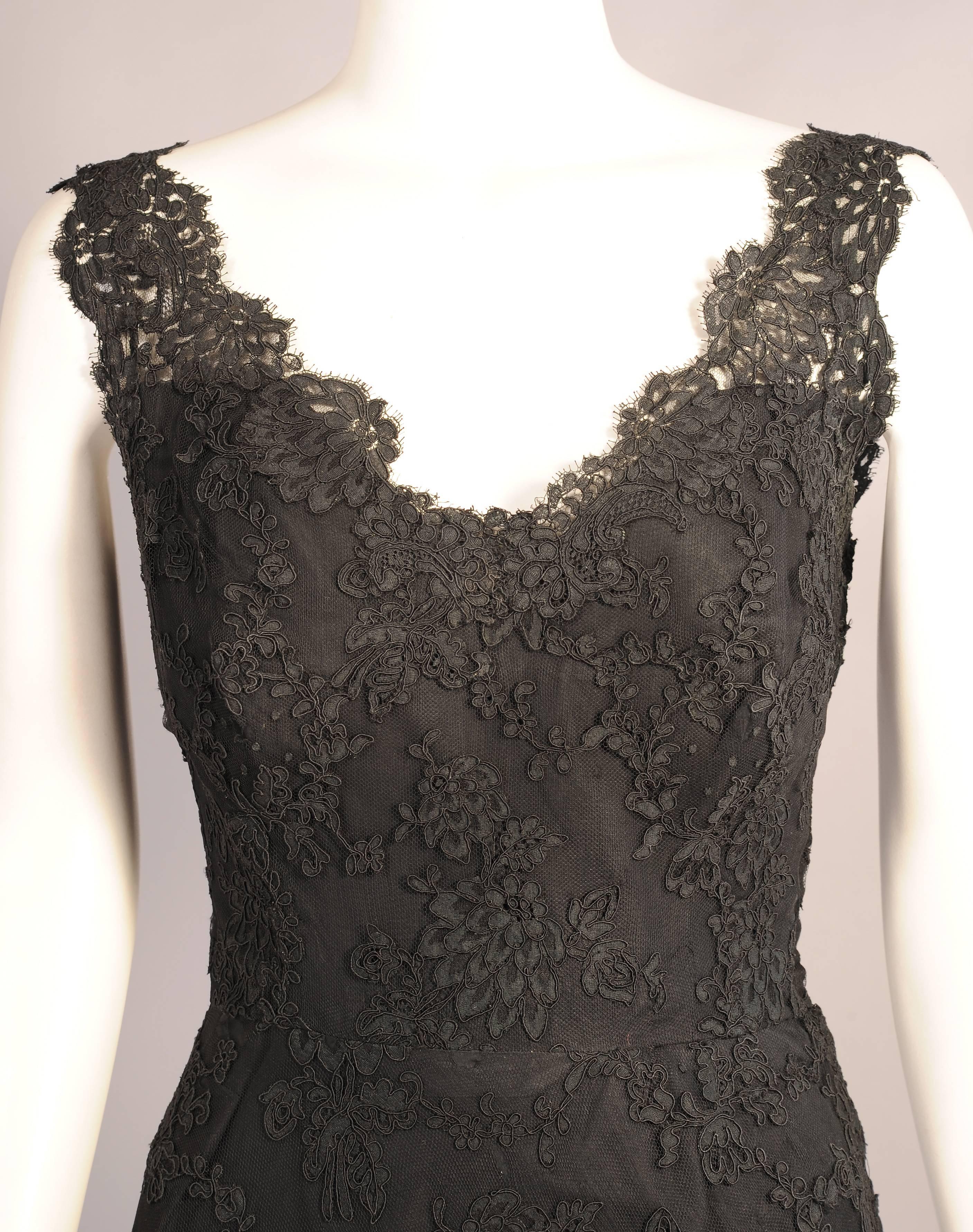 A spectacularly elegant figure hugging evening gown designed by the Spanish master Balenciaga is created from beautiful black Alencon lace. The dress is fully lined in black silk taffeta. There is a left side zipper as well as snaps and hooks and