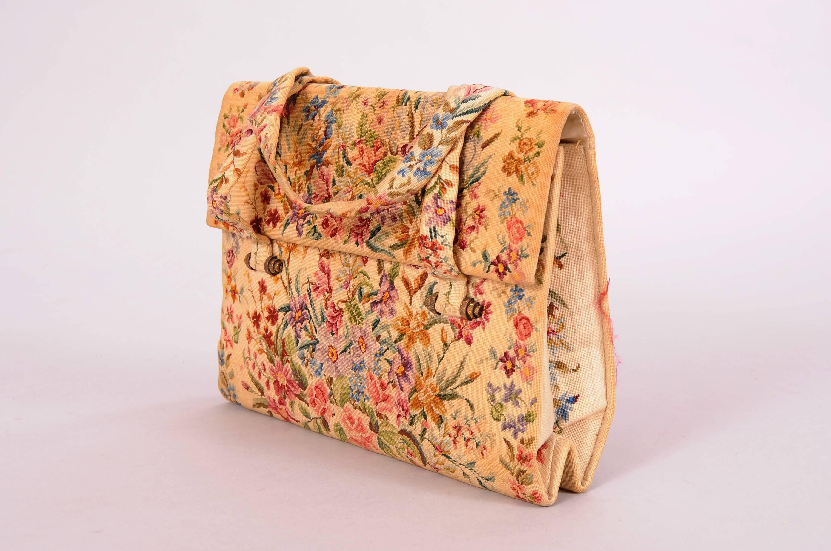 This elegant petit point bag is worked on the smallest scale and is beautifully done. The multi color floral bouquets cover the front and back of the bag with a border of flowers on each side. This border is also used for the handles. The bag is