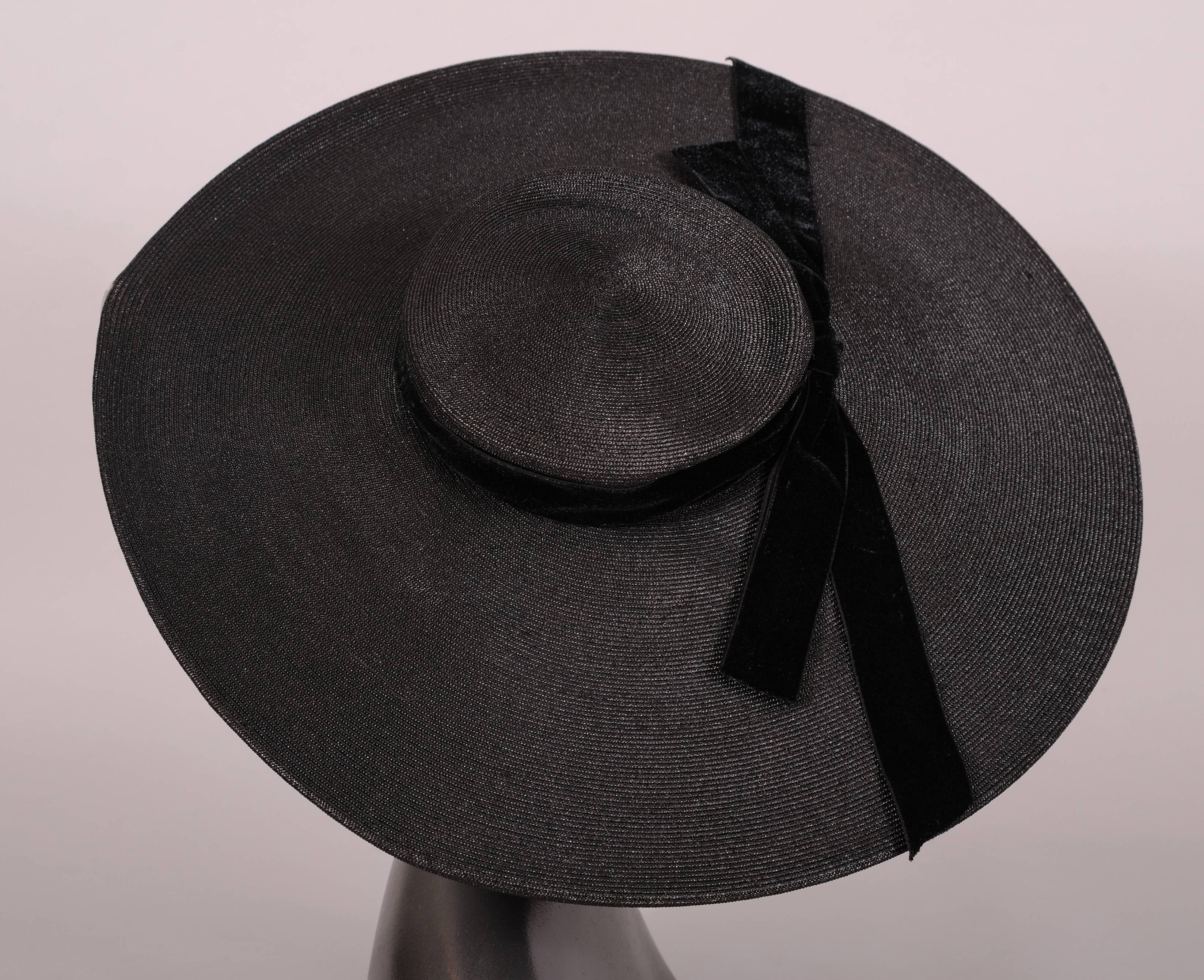An over sized black woven straw picture hat is trimmed with a black velvet ribbon at the crown. It is in excellent condition.
Measurements;
Height 3 1/2