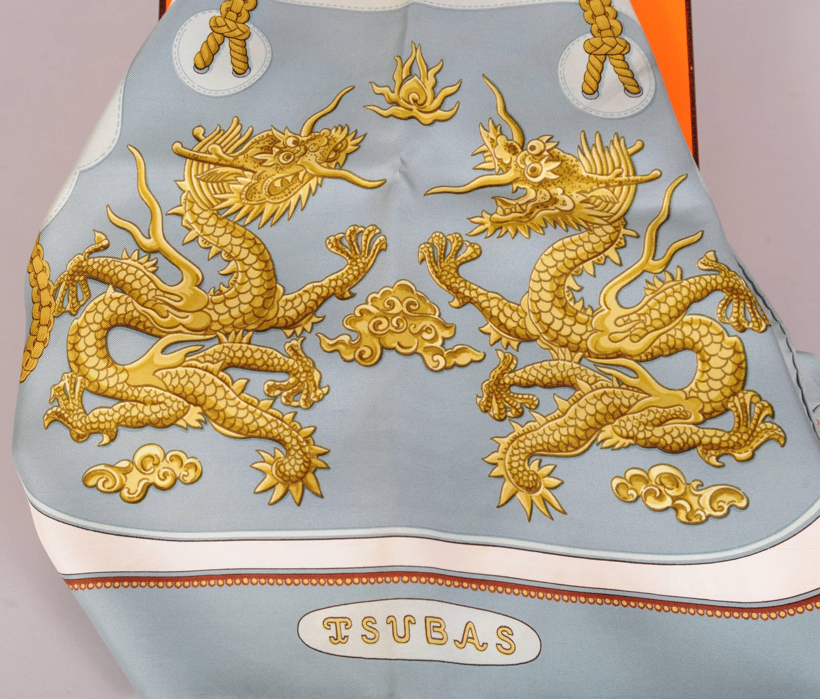 Christiane Vauzelles is the designer of this beautiful scarf depicting Tsubas, the hand guards or protective handle on a Japanese sword, which are typically enhanced with inlay or carving. This scarf is in shades of blue with gold on a white
