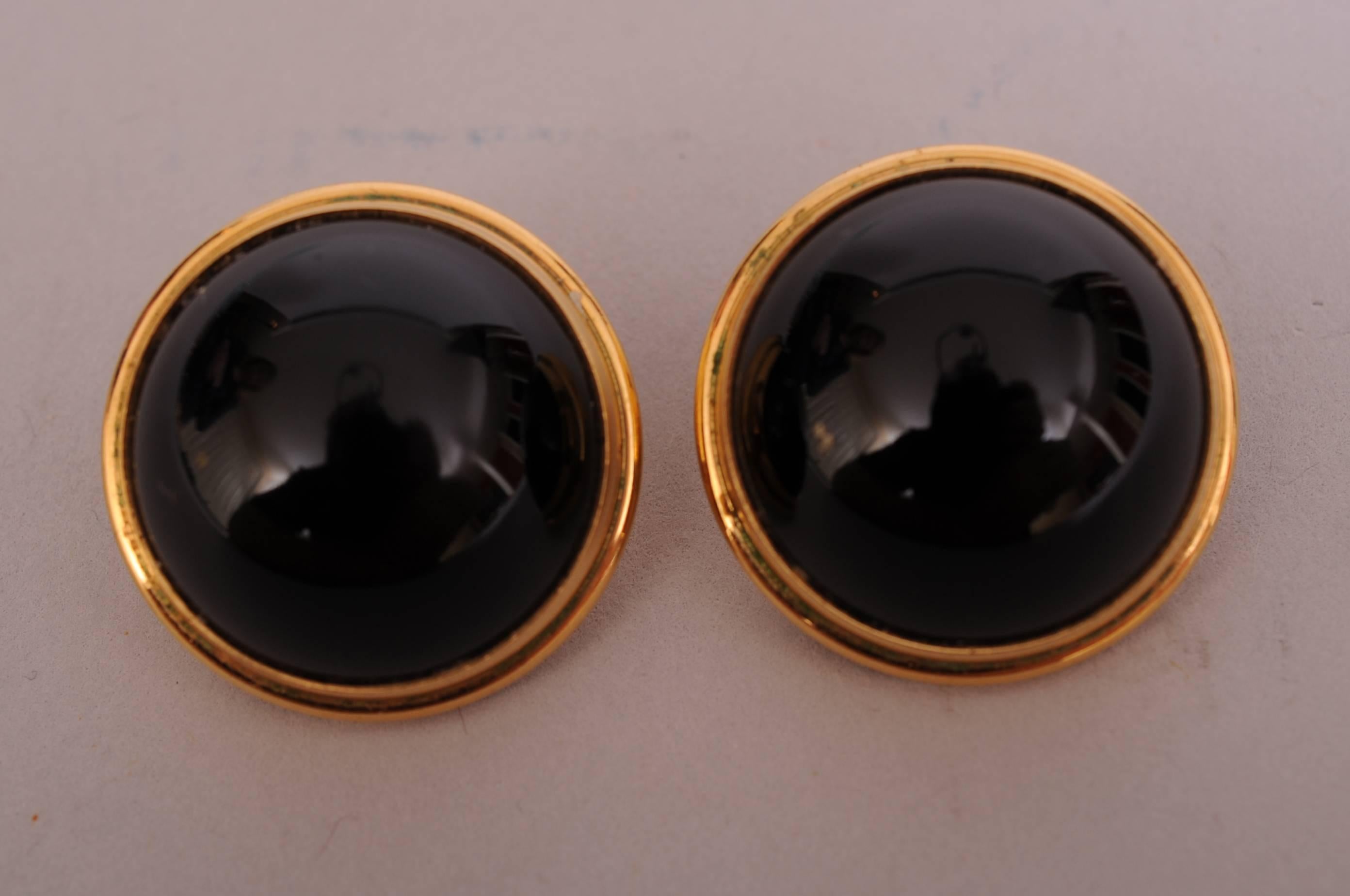 Lalique  black crystal cabochons are ringed with a raised gold toned band. The earrings are clip backs and are marked Lalique, France on the back. They are in excellent condition.
Measurements;
Height 1/2