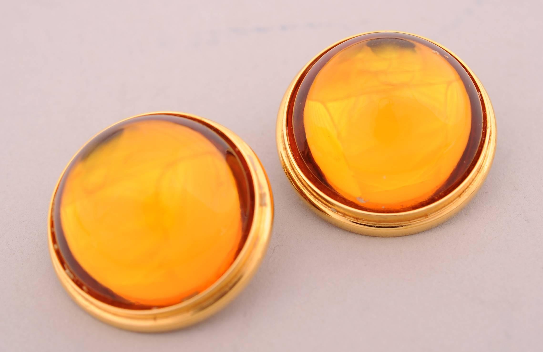 Lalique  gold crystal cabochons are ringed with a raised gold toned band. The earrings are clip backs and are marked Lalique, France on the back. They are in excellent condition.
Measurements;
Height 1/2